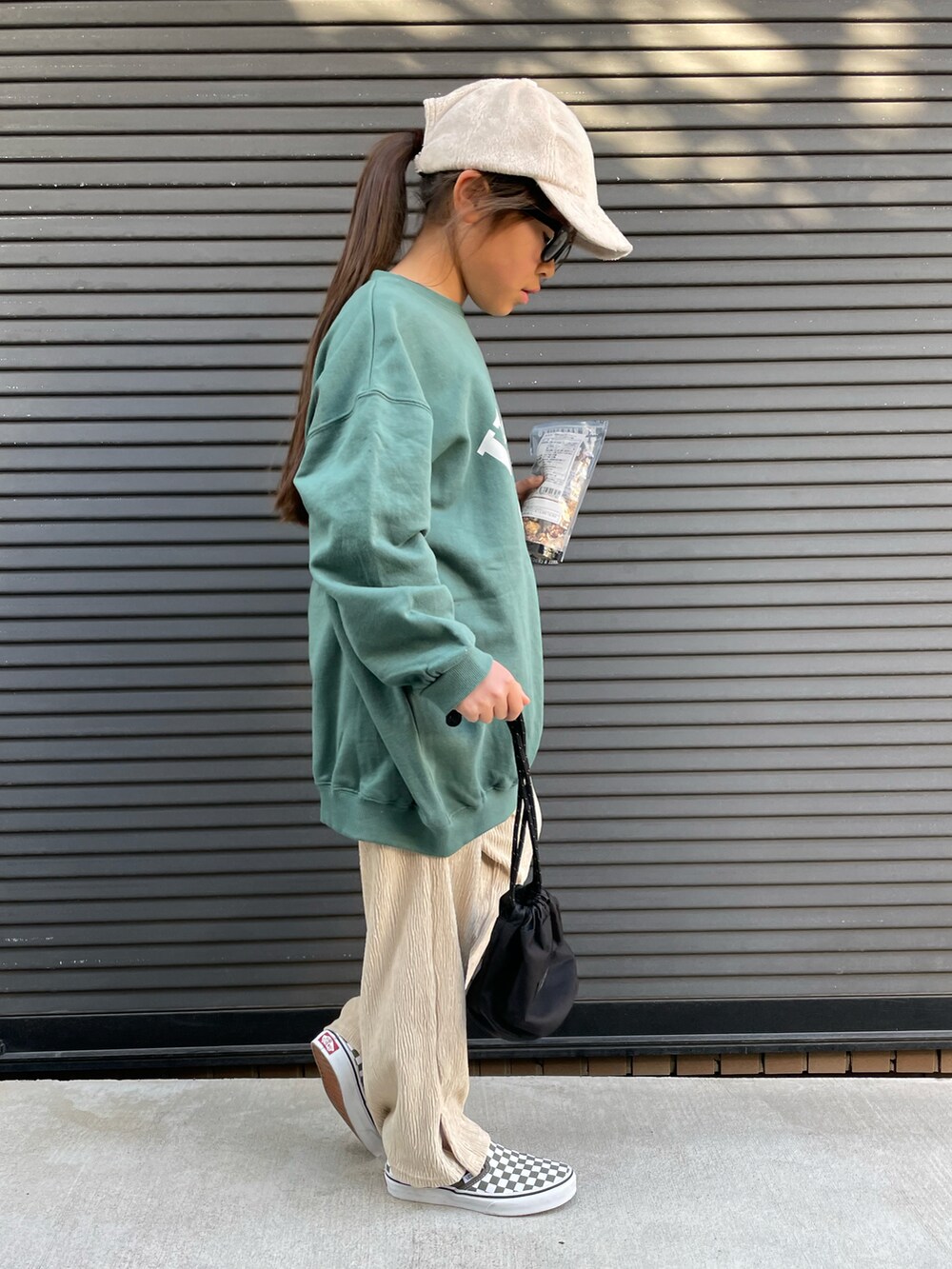 グリーン系のスウェット、ベージュ系のその他パンツ、ブラック系のトートバッグを着用したキッズの冬コーディネートの3枚目の写真