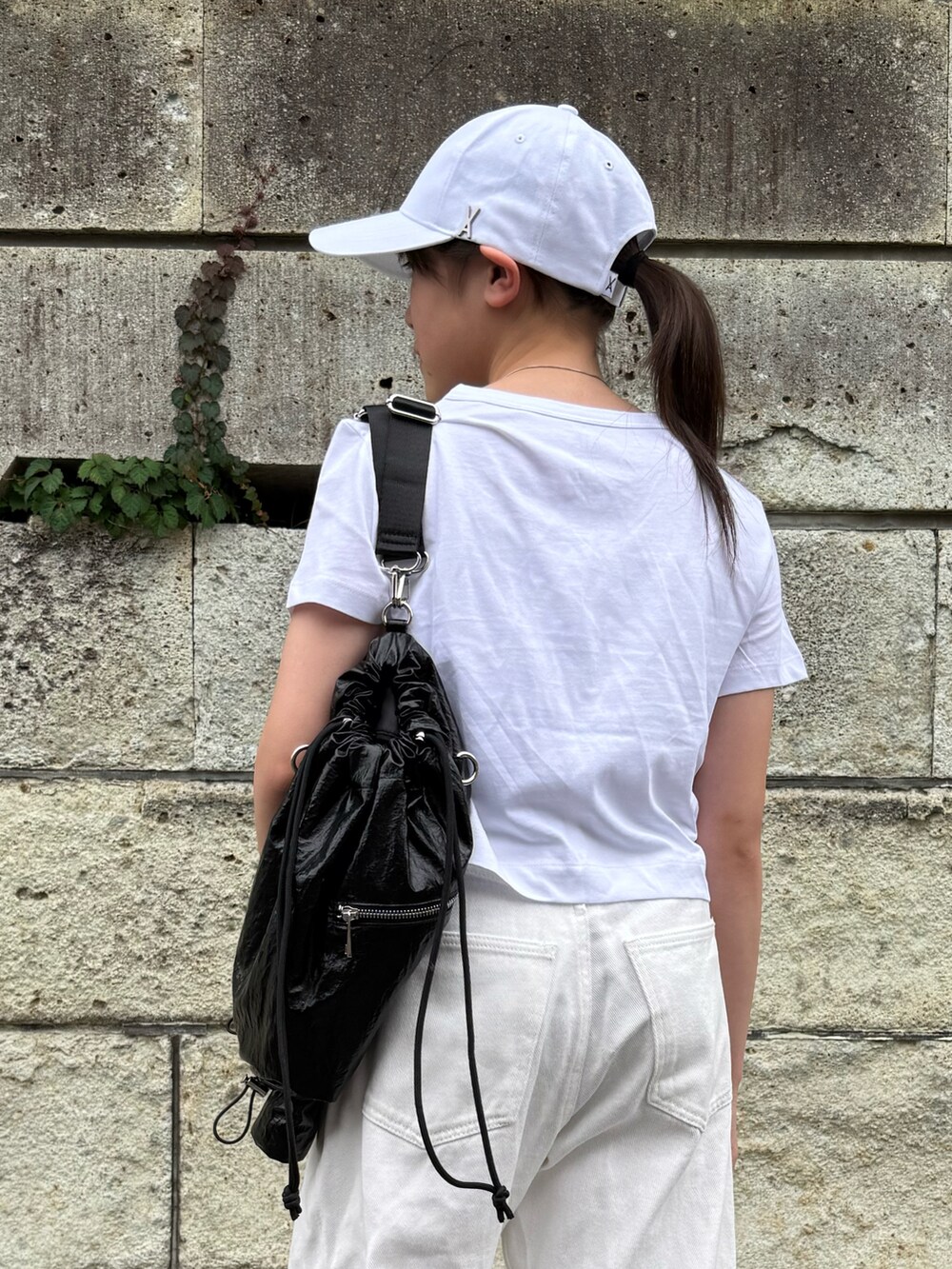 ホワイト系のデニムパンツ、ホワイト系のTシャツ/カットソー、ブラック系のショルダーバッグを着用したキッズの春コーディネートの4枚目の写真