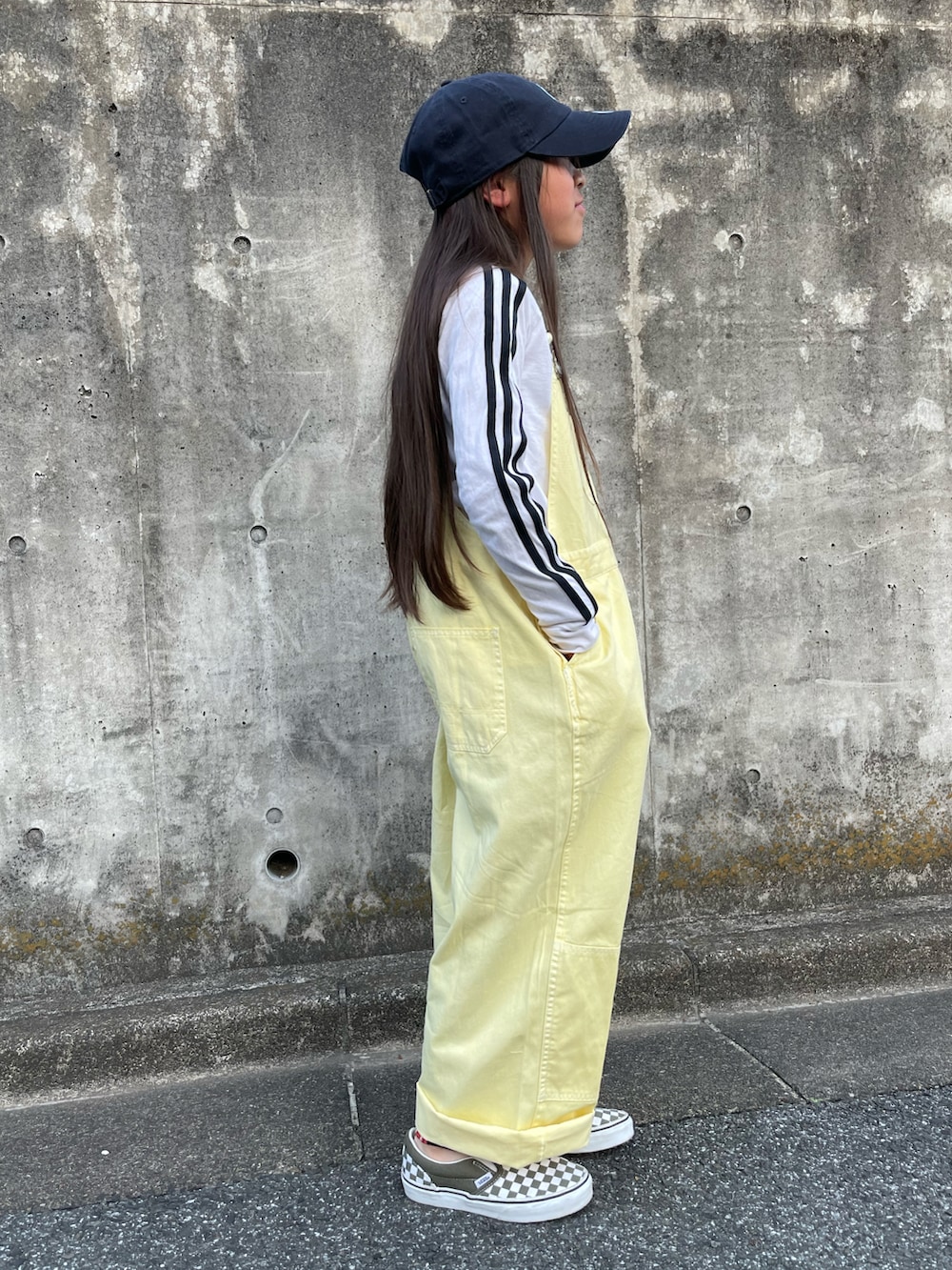 イエロー系のサロペット/オーバーオール、ホワイト系のTシャツ/カットソー、グリーン系のスニーカーを着用したキッズの春コーディネートの3枚目の写真