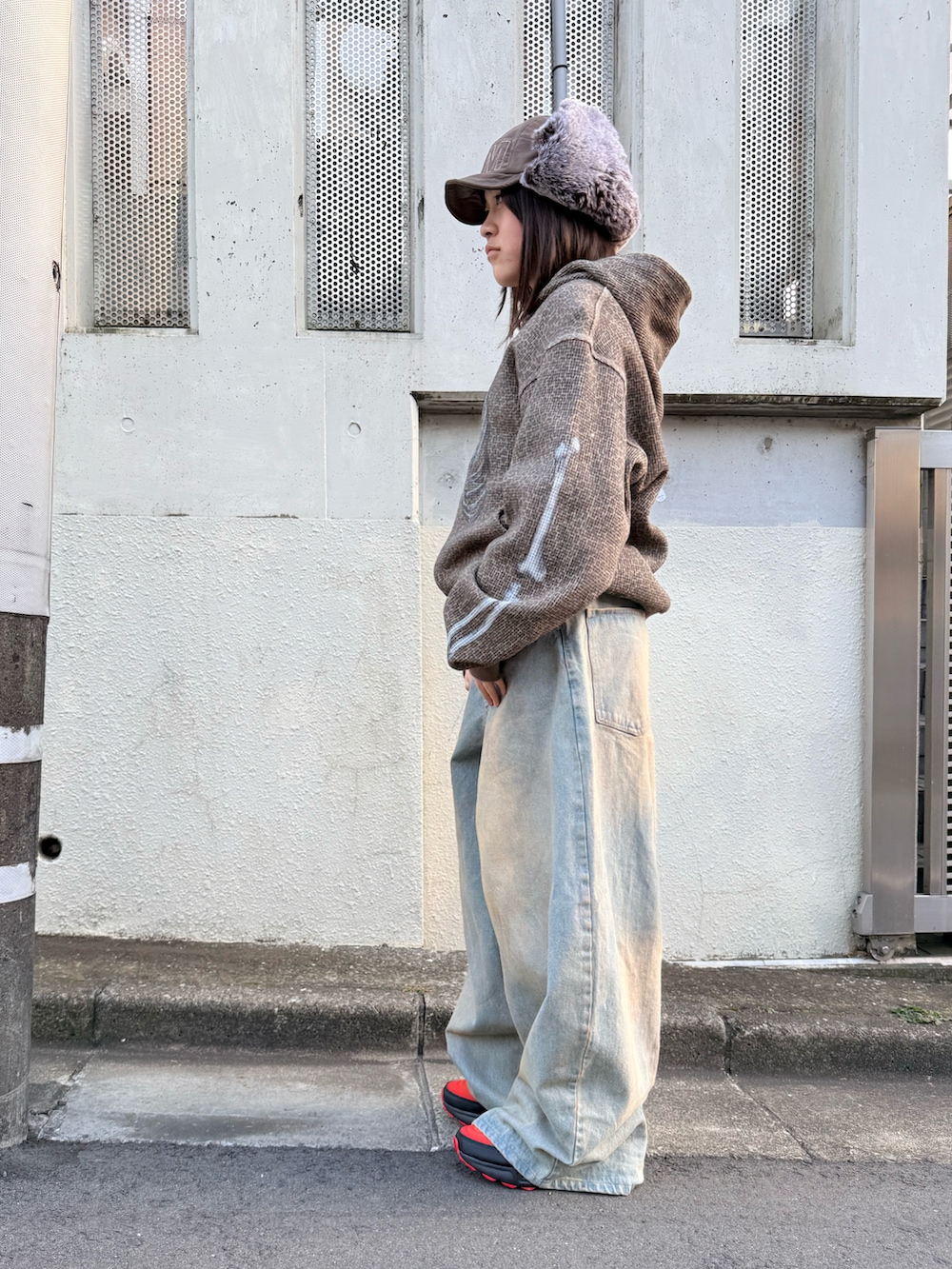 ブラック系のスニーカー、ブルー系のデニムパンツ、その他のパーカーを着用したレディースの冬コーディネートの3枚目の写真