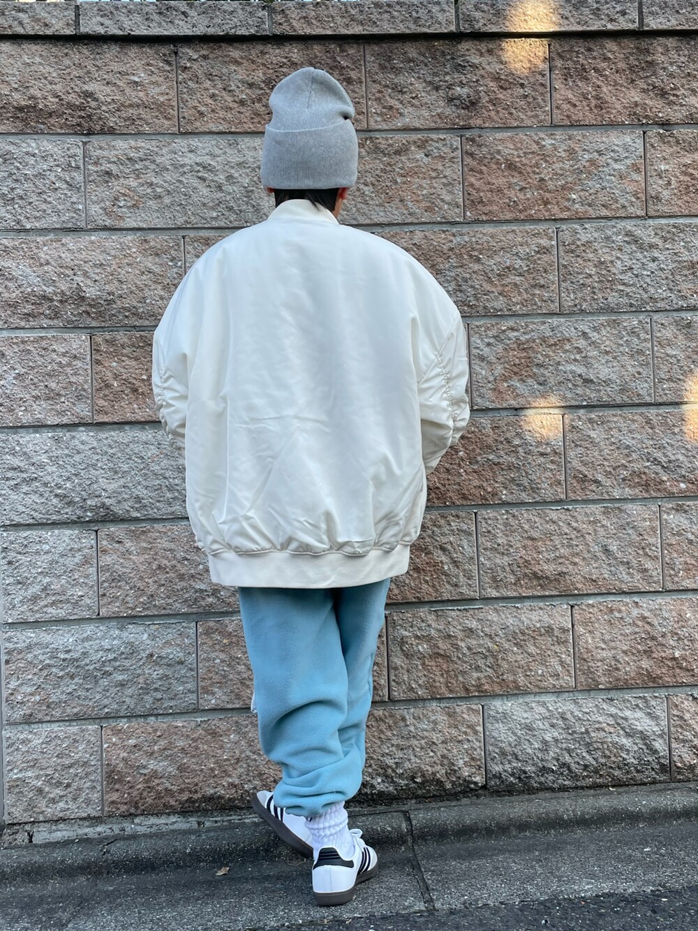 ホワイト系のミリタリージャケット、グレー系のスウェット、ブルー系のその他パンツを着用したキッズの秋コーディネートの3枚目の写真