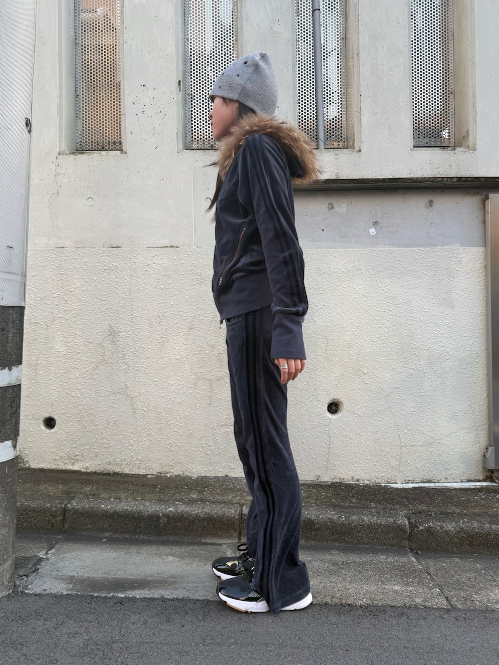 ブルー系のセットアップ、ブラック系のスニーカー、グレー系のニットキャップ/ビーニーを着用したレディースの冬コーディネートの2枚目の写真