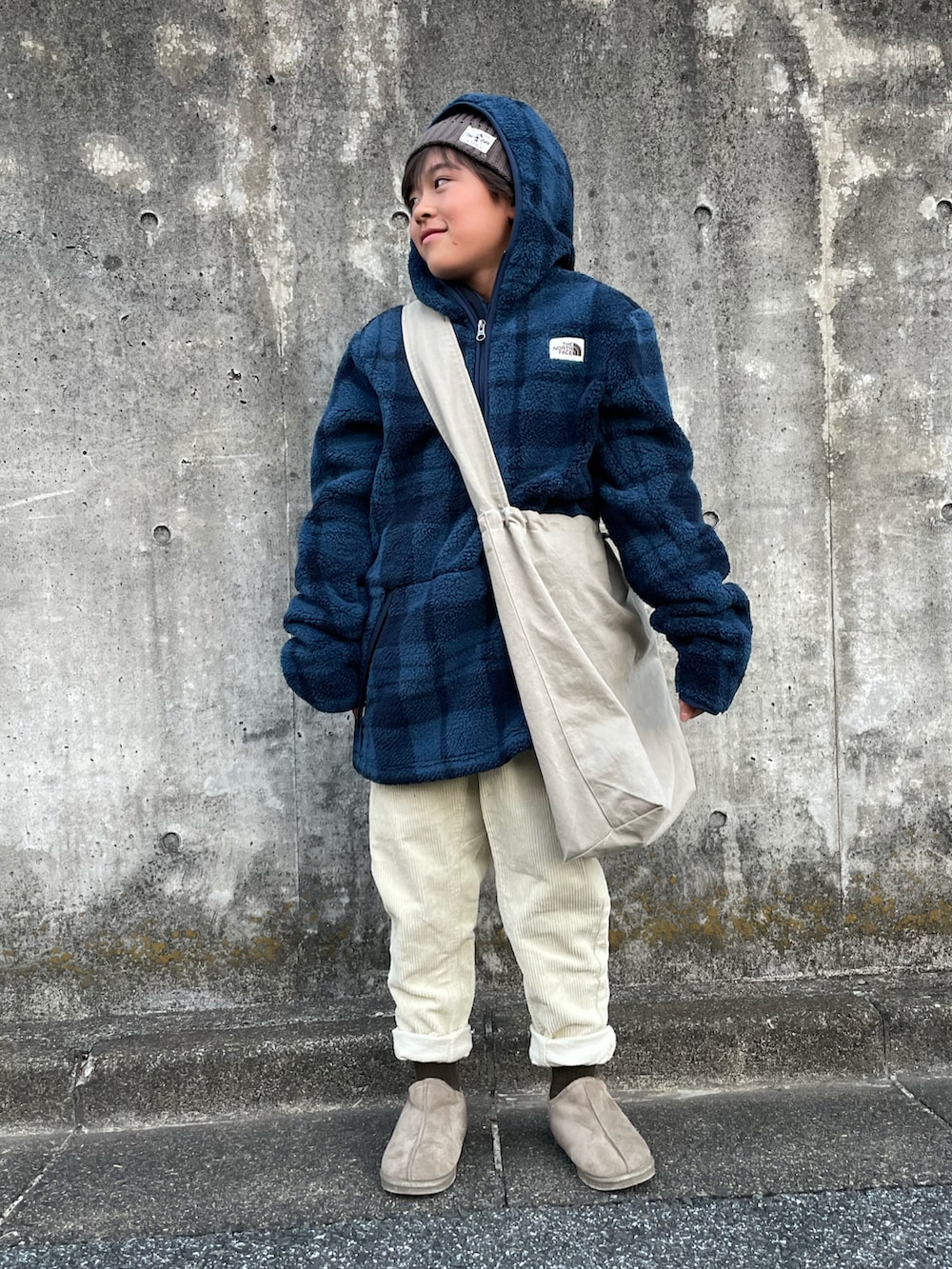 ブルー系のパーカー、ホワイト系のその他パンツ、ベージュ系のショルダーバッグを着用したキッズの冬コーディネートの4枚目の写真