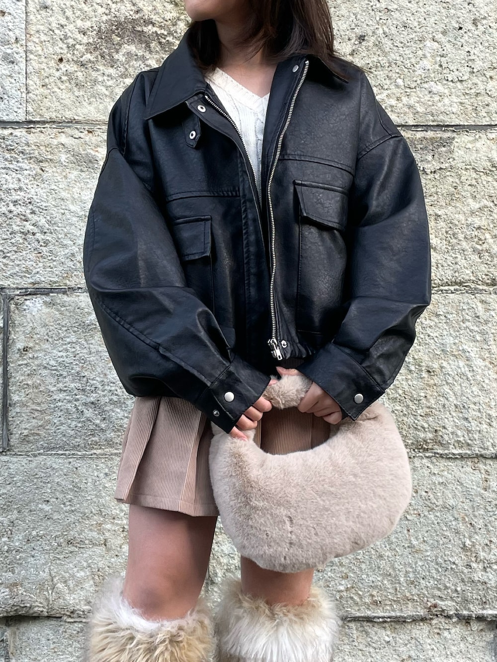 ブラック系のブルゾン、ホワイト系のニット/セーター、ベージュ系のスカートを着用したキッズの冬コーディネートの4枚目の写真