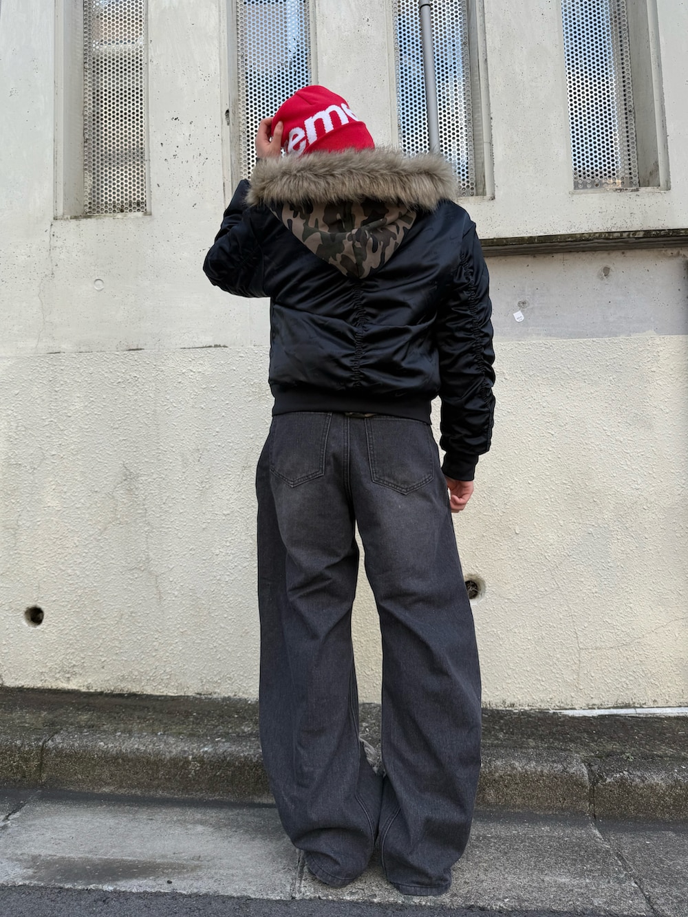 ブラック系のデニムパンツ、グリーン系のパーカー、ブラック系のブルゾンを着用したレディースの冬コーディネートの4枚目の写真