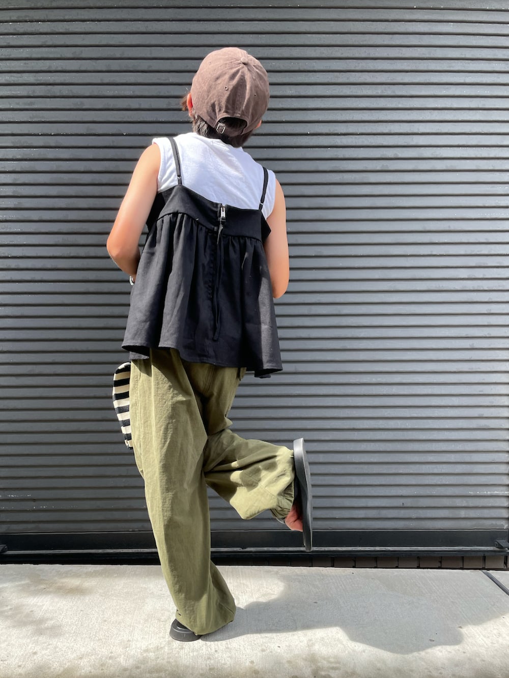 ブラック系のキャミソール、グリーン系のカーゴパンツ、ホワイト系のタンクトップを着用したキッズの夏コーディネートの4枚目の写真