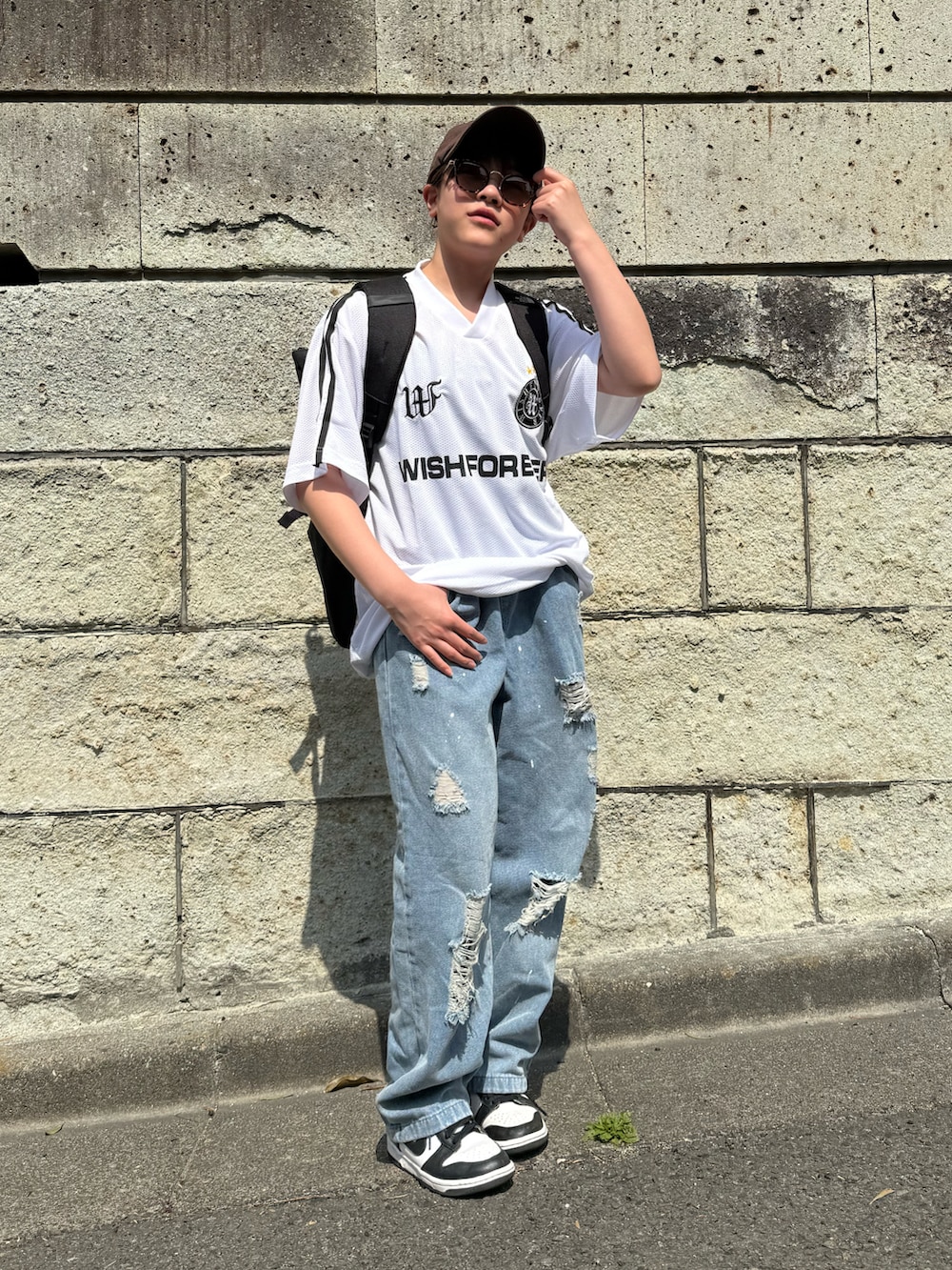 ホワイト系のTシャツ/カットソー、ブルー系のデニムパンツ、ブラック系のバックパック/リュックを着用したキッズの春コーディネートの2枚目の写真