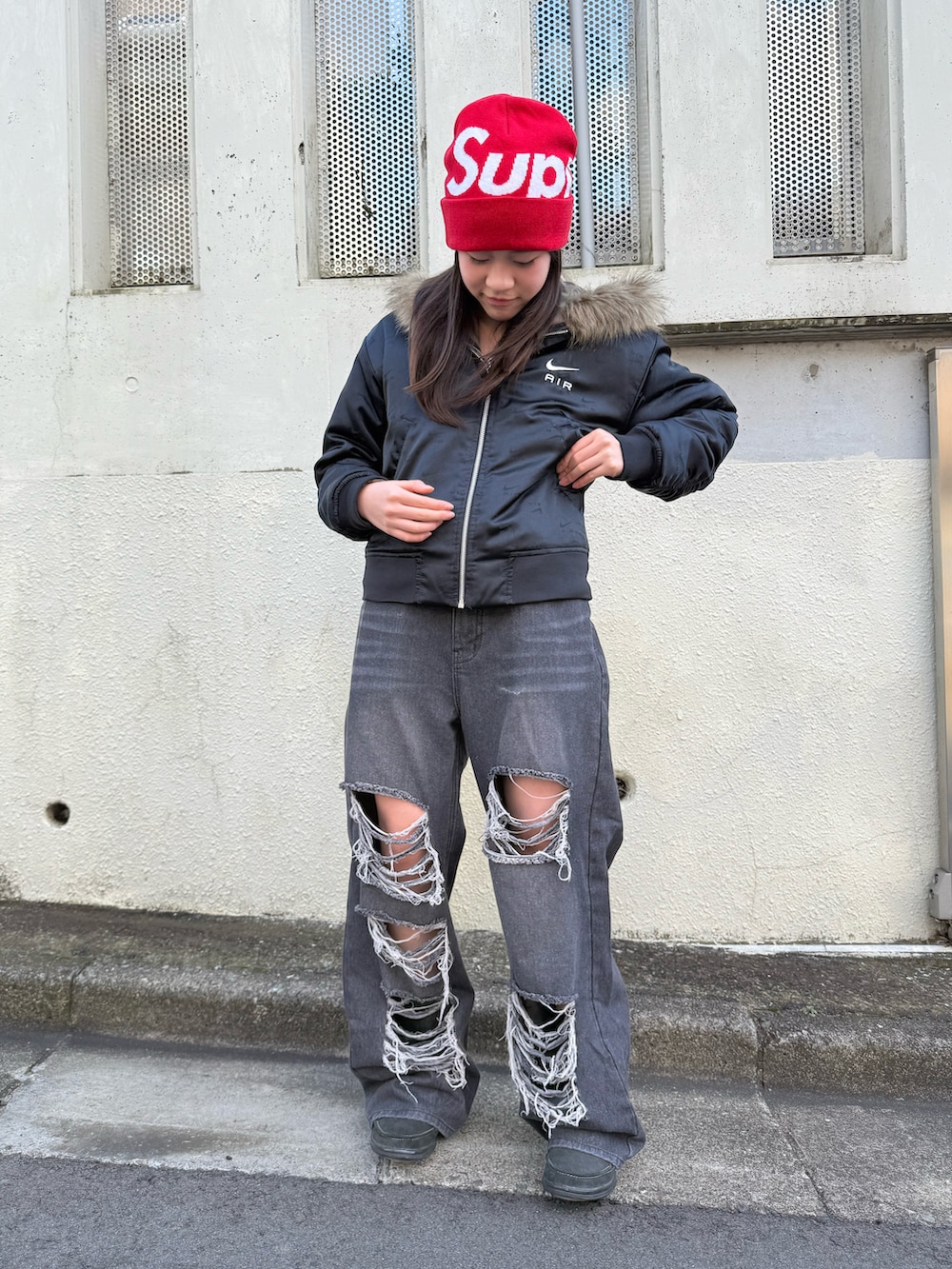 ブラック系のデニムパンツ、グリーン系のパーカー、ブラック系のブルゾンを着用したレディースの冬コーディネートの2枚目の写真