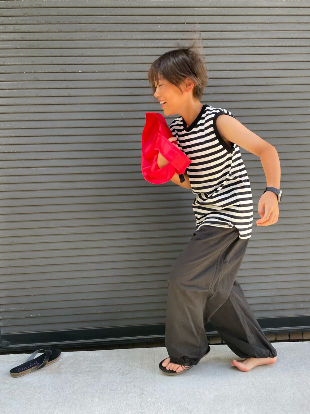 ブラック系のタンクトップ、ブラック系のその他パンツ、レッド系のエコバッグ/サブバッグを着用したキッズの夏コーディネートの5枚目の写真