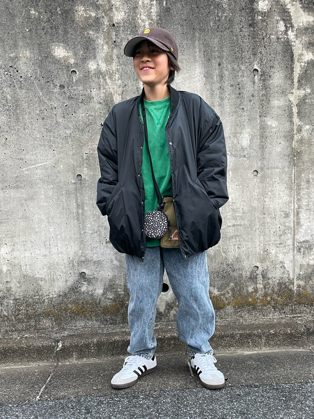 ブラック系のブルゾン、グリーン系のスウェット、ブルー系のデニムパンツを着用したキッズの冬コーディネートの4枚目の写真