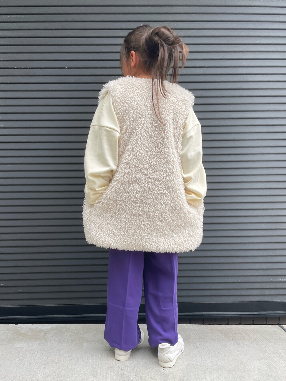 ホワイト系のベスト、ホワイト系のスウェット、パープル系のその他パンツを着用したキッズの秋コーディネートの3枚目の写真