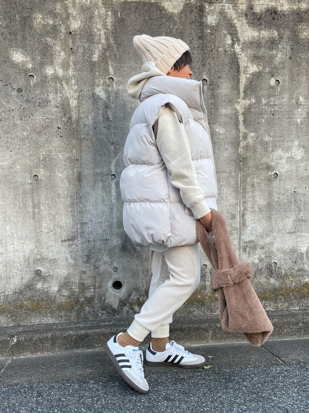 ホワイト系のダウンベスト、ホワイト系のアンサンブル、ホワイト系のパンツを着用したキッズの冬コーディネートの2枚目の写真