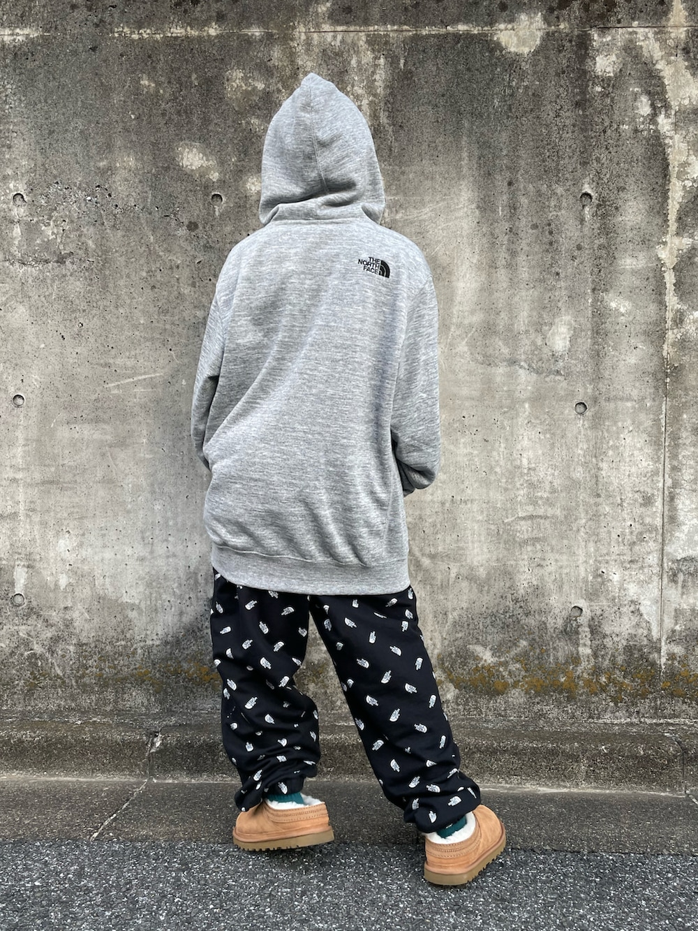 グレー系のパーカー、ブラック系のスウェットパンツ、グリーン系のショルダーバッグを着用したキッズの冬コーディネートの3枚目の写真