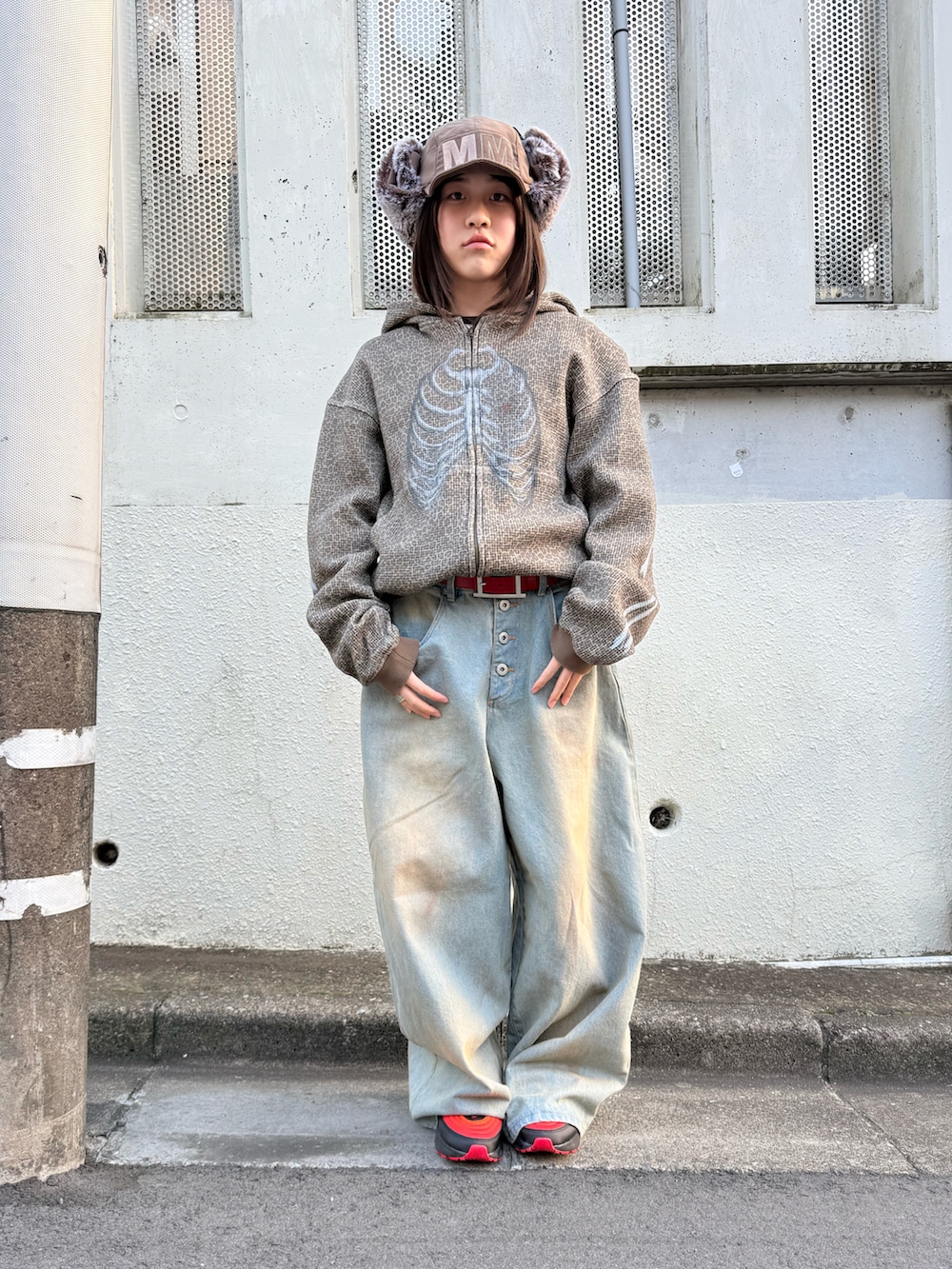 ブラック系のスニーカー、ブルー系のデニムパンツ、その他のパーカーを着用したレディースの冬コーディネートの5枚目の写真