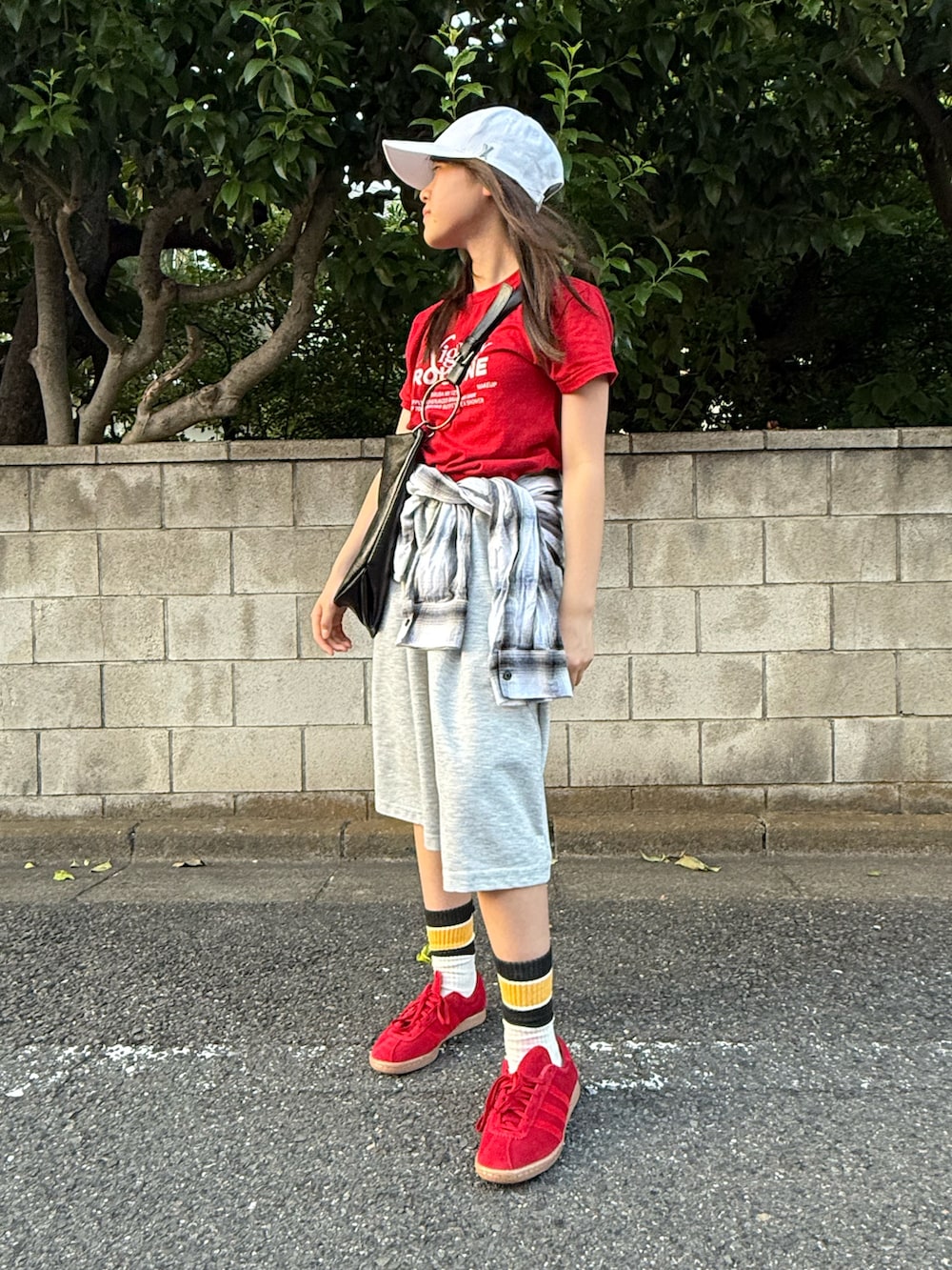 グレー系のスウェットパンツ、レッド系のTシャツ/カットソー、ブラック系のトートバッグを着用したレディースの秋コーディネートの4枚目の写真