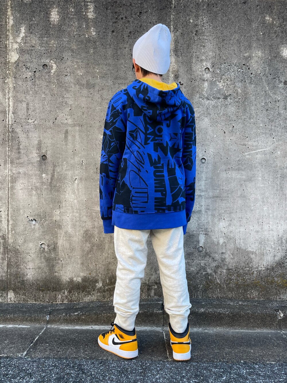 ブルー系のパーカー、ベージュ系のスウェットパンツ、オレンジ系のスニーカーを着用したキッズの秋コーディネートの3枚目の写真