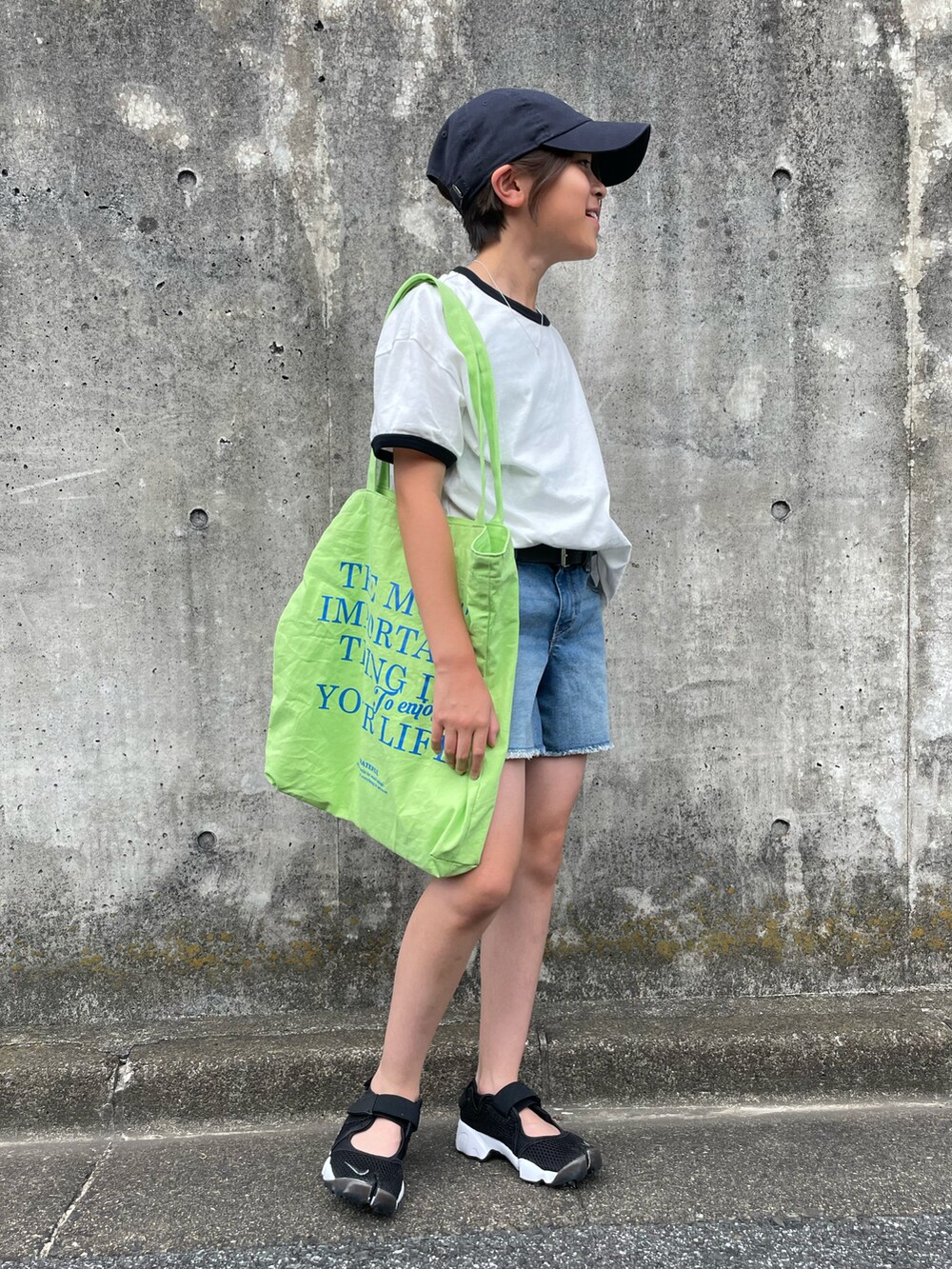 ホワイト系のTシャツ/カットソー、ブルー系のデニムパンツ、グリーン系のトートバッグを着用したキッズの夏コーディネートの3枚目の写真