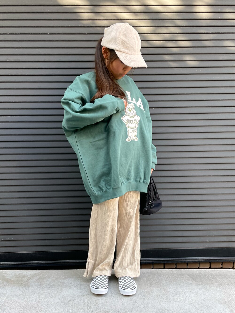 グリーン系のスウェット、ベージュ系のその他パンツ、ブラック系のトートバッグを着用したキッズの冬コーディネートの2枚目の写真
