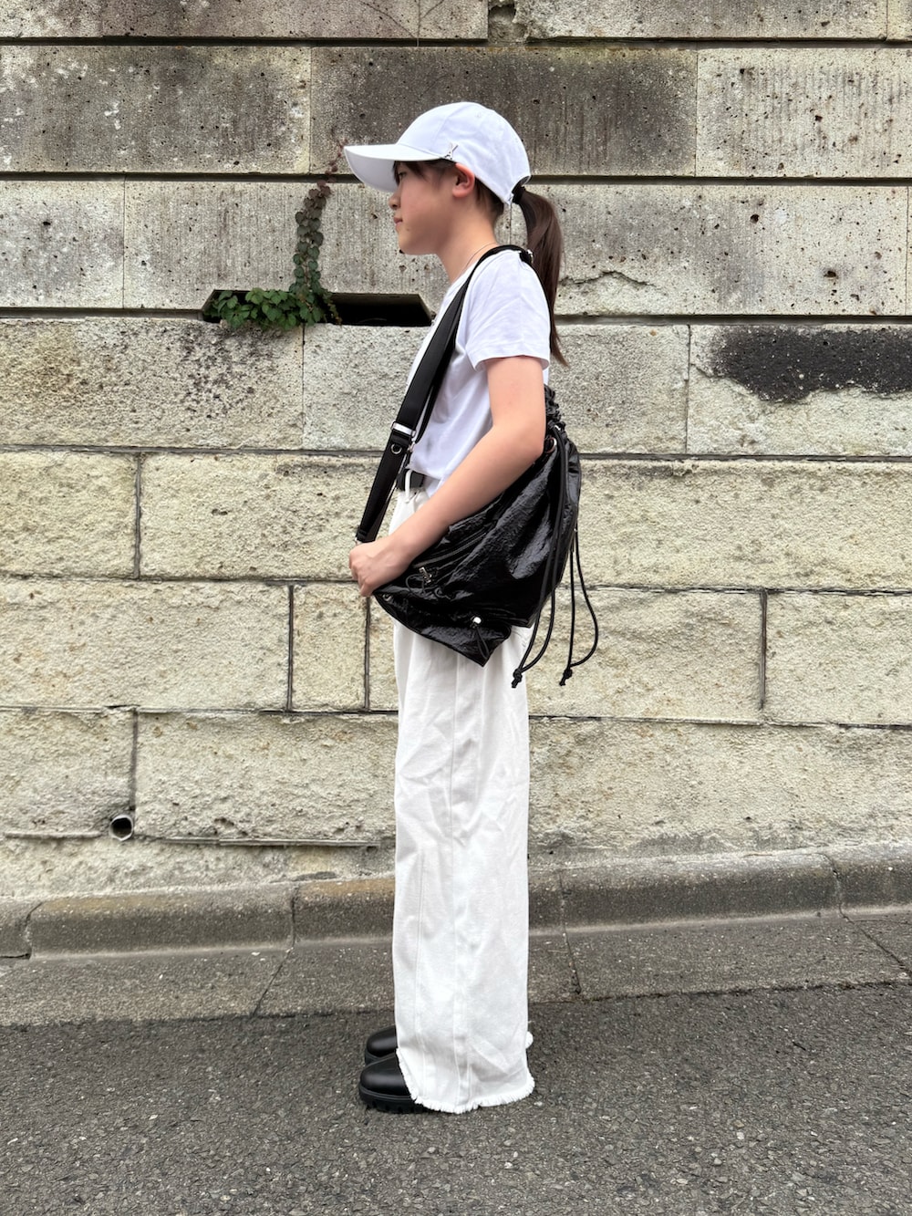 ホワイト系のデニムパンツ、ホワイト系のTシャツ/カットソー、ブラック系のショルダーバッグを着用したキッズの春コーディネートの2枚目の写真
