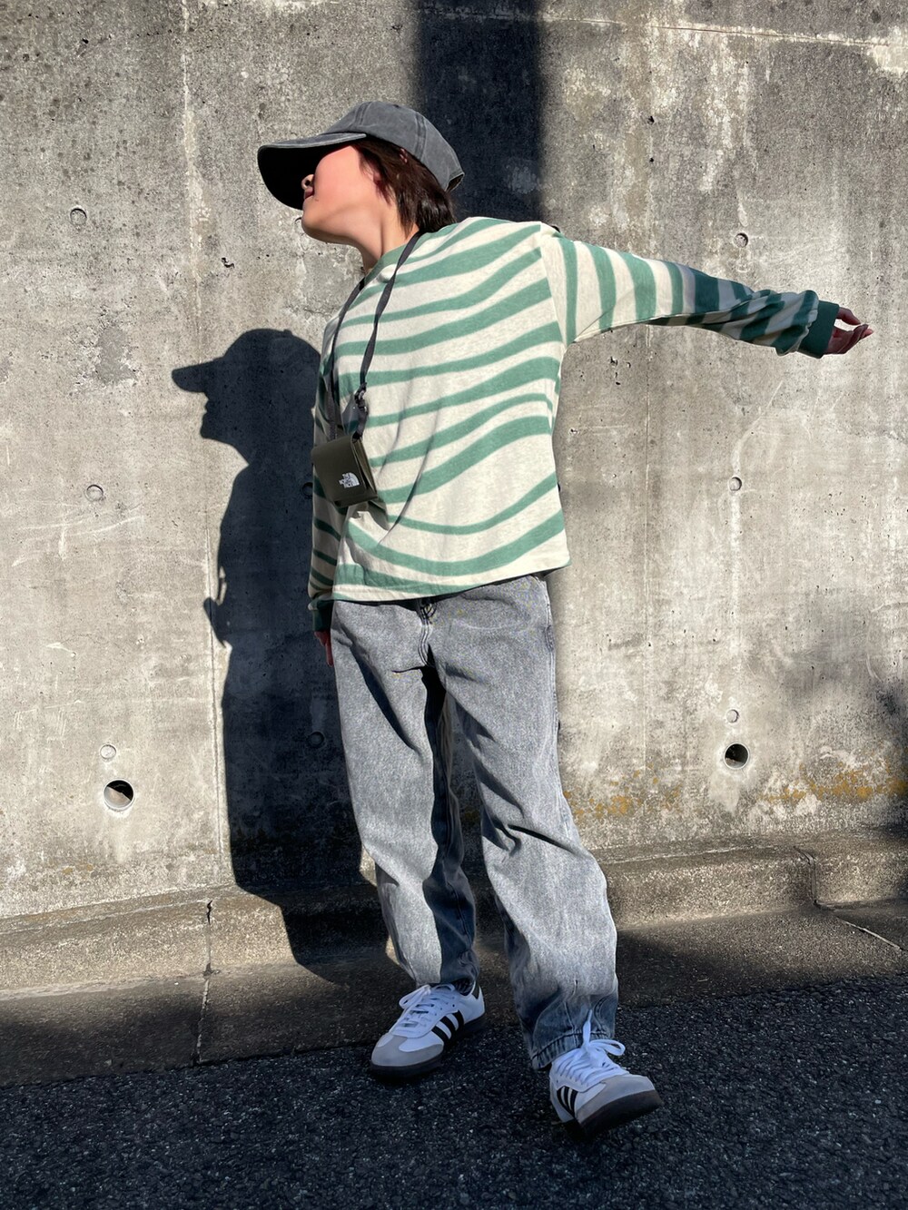 グリーン系のTシャツ/カットソー、ブラック系のデニムパンツ、グリーン系のショルダーバッグを着用したキッズの春コーディネートの4枚目の写真