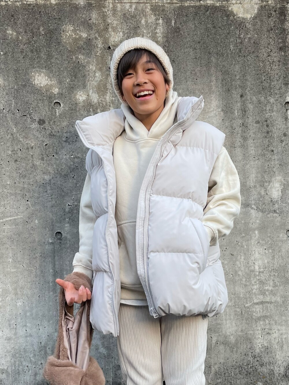 ホワイト系のダウンベスト、ホワイト系のアンサンブル、ホワイト系のパンツを着用したキッズの冬コーディネートの5枚目の写真