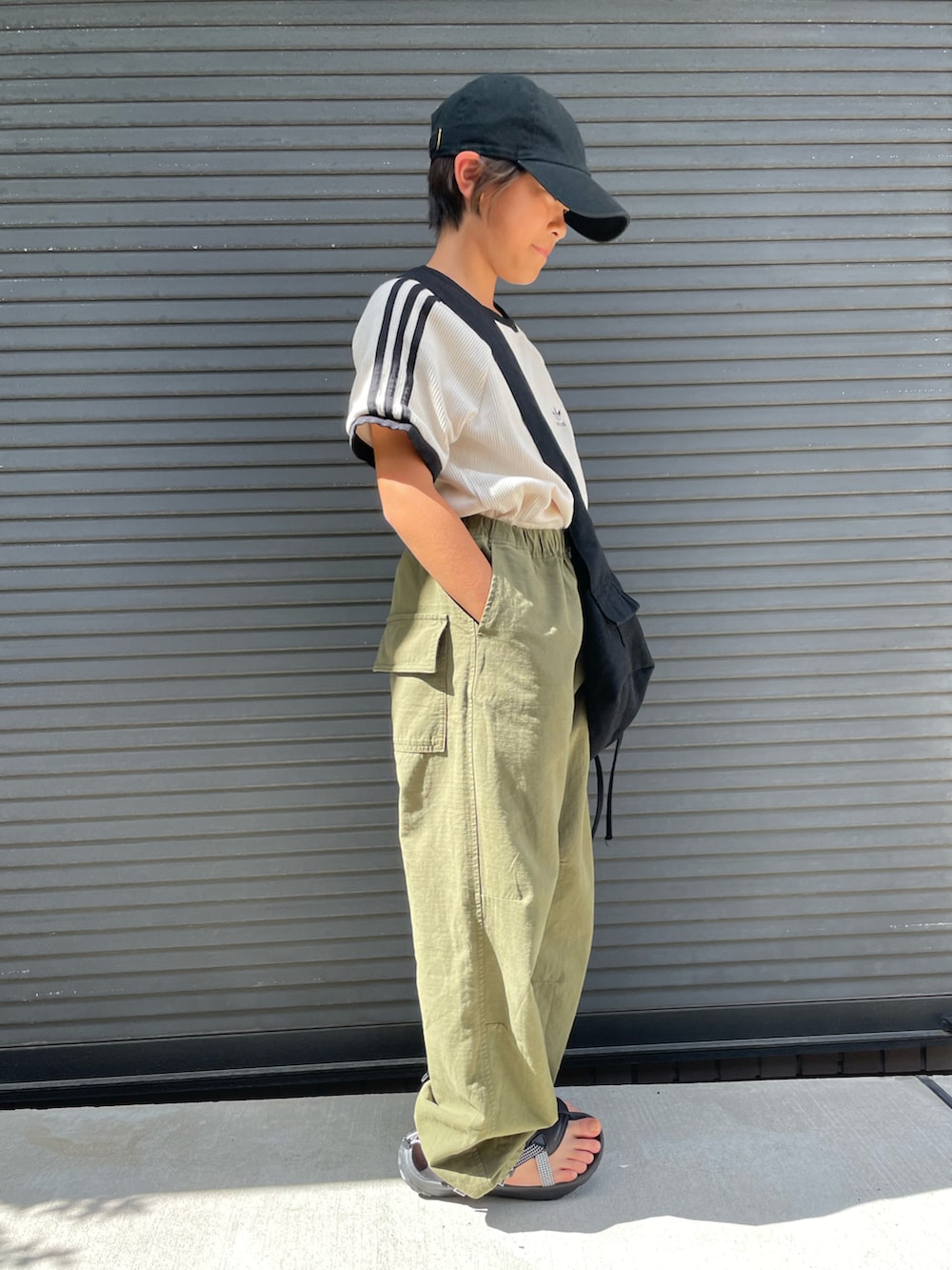 ホワイト系のTシャツ/カットソー、グリーン系のカーゴパンツ、ブラック系のショルダーバッグを着用したキッズの夏コーディネートの2枚目の写真