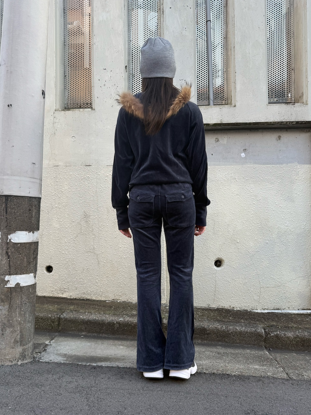 ブルー系のセットアップ、ブラック系のスニーカー、グレー系のニットキャップ/ビーニーを着用したレディースの冬コーディネートの3枚目の写真