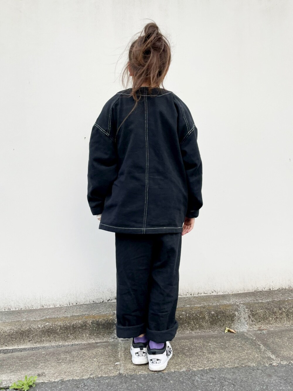 ブラック系のノーカラージャケット、ブラック系のその他パンツ、ホワイト系のTシャツ/カットソーを着用したキッズの春コーディネートの2枚目の写真