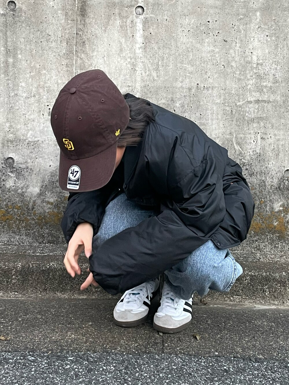 ブラック系のブルゾン、グリーン系のスウェット、ブルー系のデニムパンツを着用したキッズの冬コーディネートの5枚目の写真