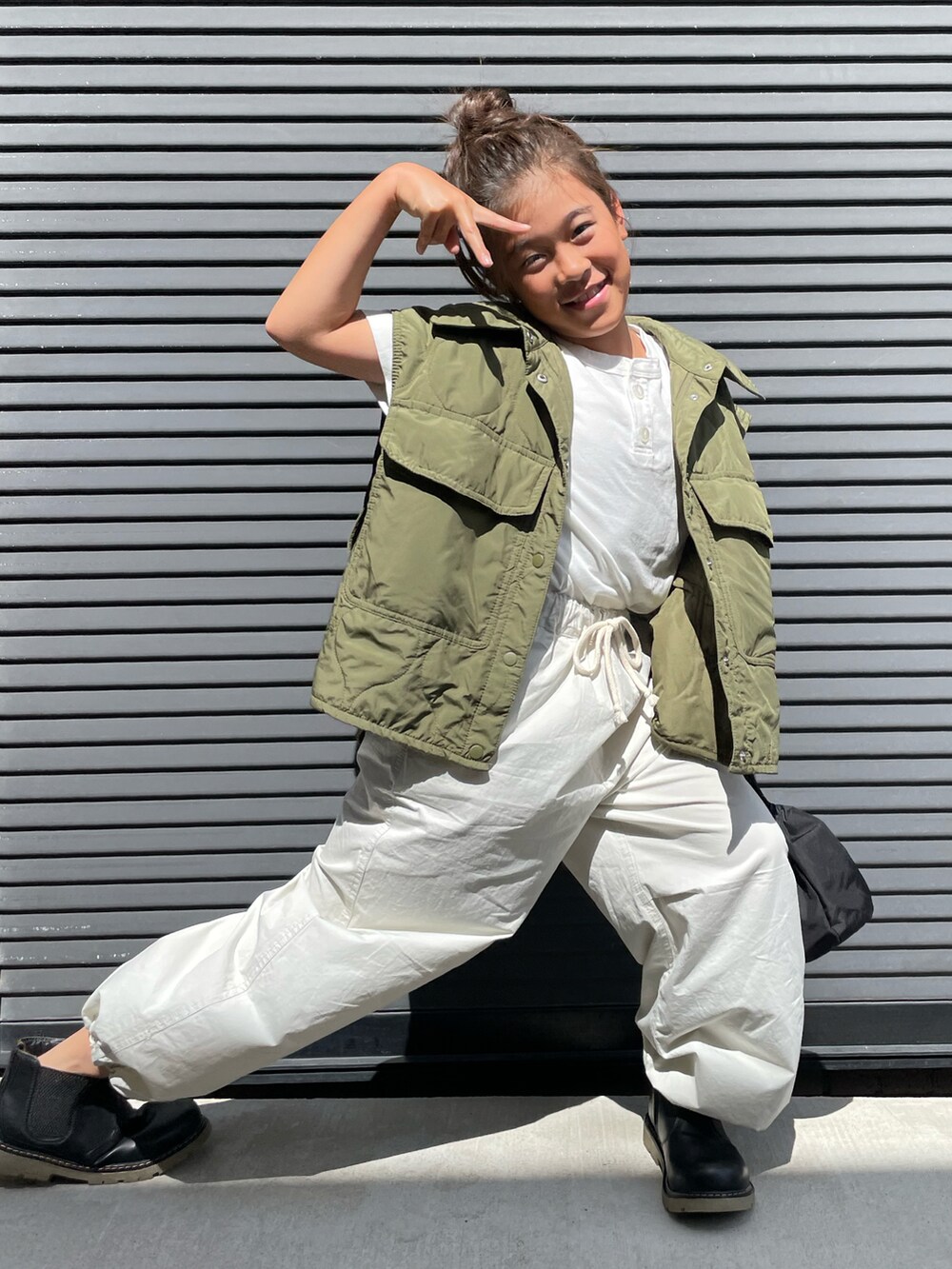 グリーン系のミリタリージャケット、ホワイト系のTシャツ/カットソー、ホワイト系のその他パンツを着用したキッズの秋コーディネートの5枚目の写真