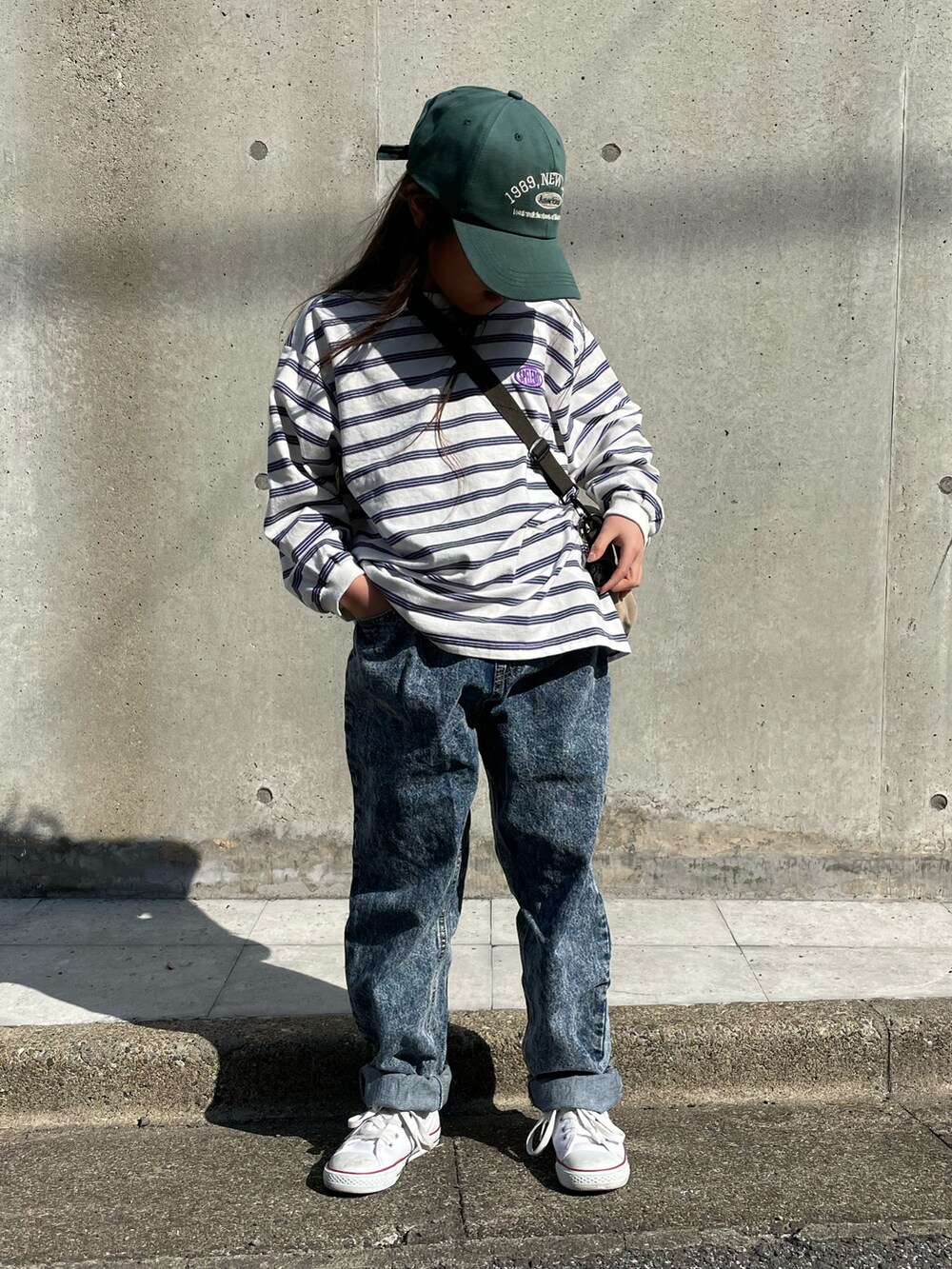 ホワイト系のTシャツ/カットソー、ブルー系のその他パンツ、ベージュ系のショルダーバッグを着用したキッズの春コーディネートの2枚目の写真