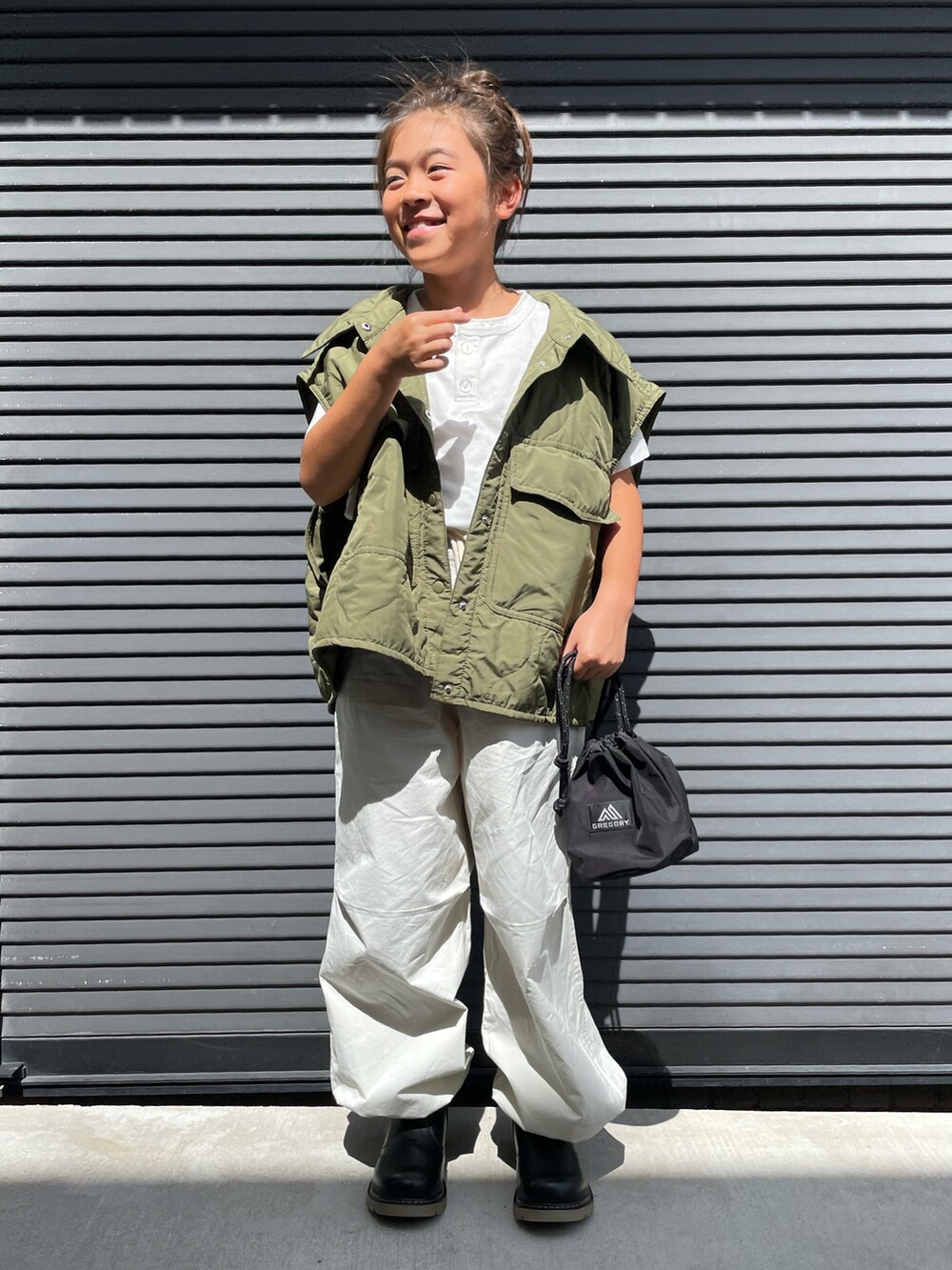 グリーン系のミリタリージャケット、ホワイト系のTシャツ/カットソー、ホワイト系のその他パンツを着用したキッズの秋コーディネートの4枚目の写真