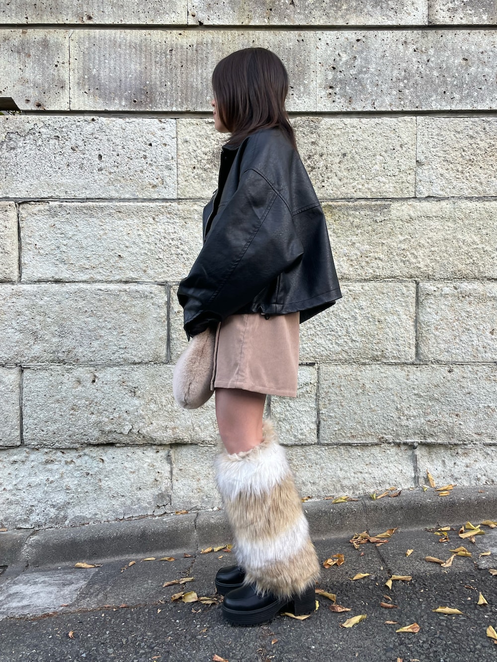 ブラック系のブルゾン、ホワイト系のニット/セーター、ベージュ系のスカートを着用したキッズの冬コーディネートの2枚目の写真