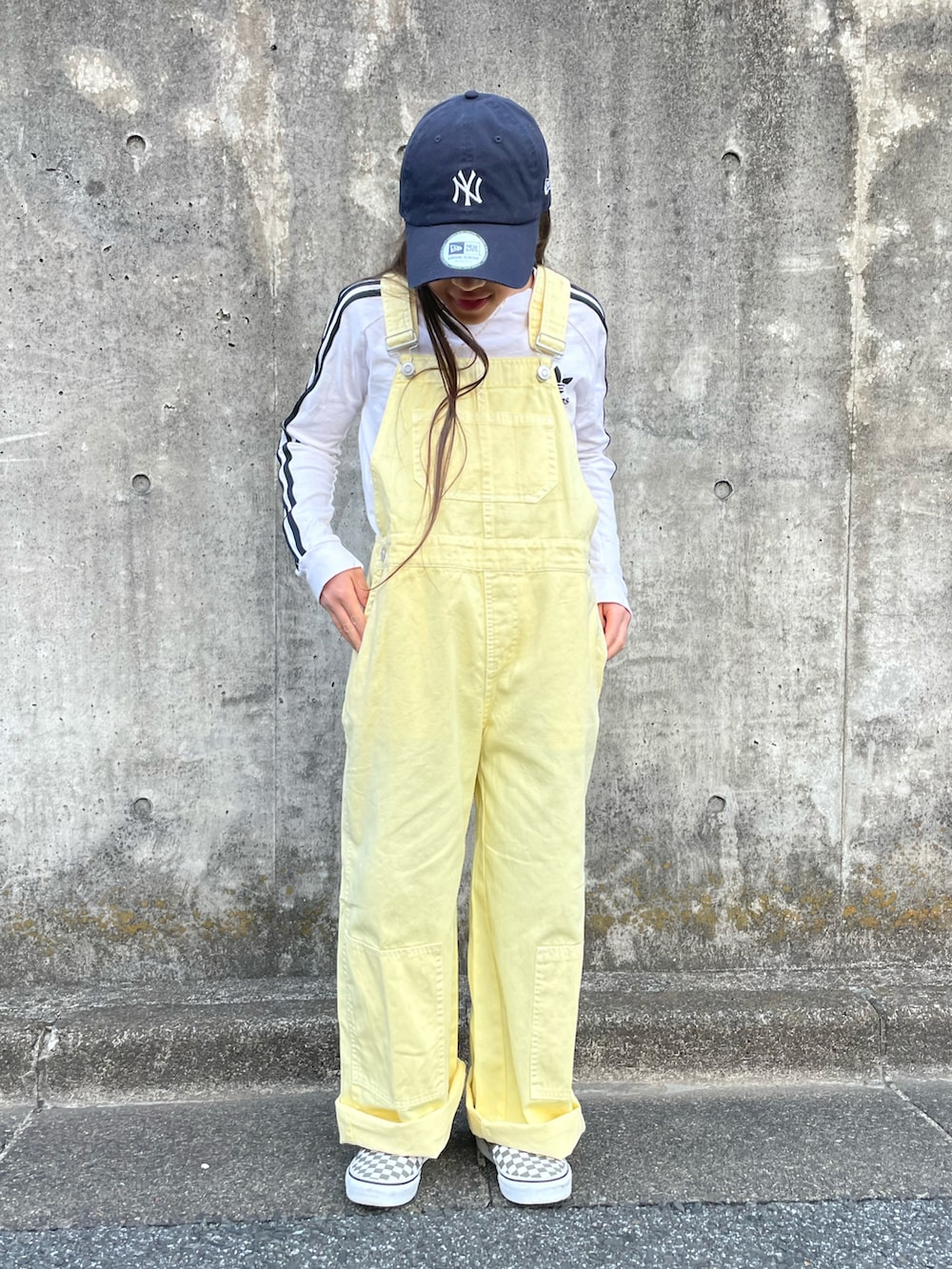 イエロー系のサロペット/オーバーオール、ホワイト系のTシャツ/カットソー、グリーン系のスニーカーを着用したキッズの春コーディネートの2枚目の写真