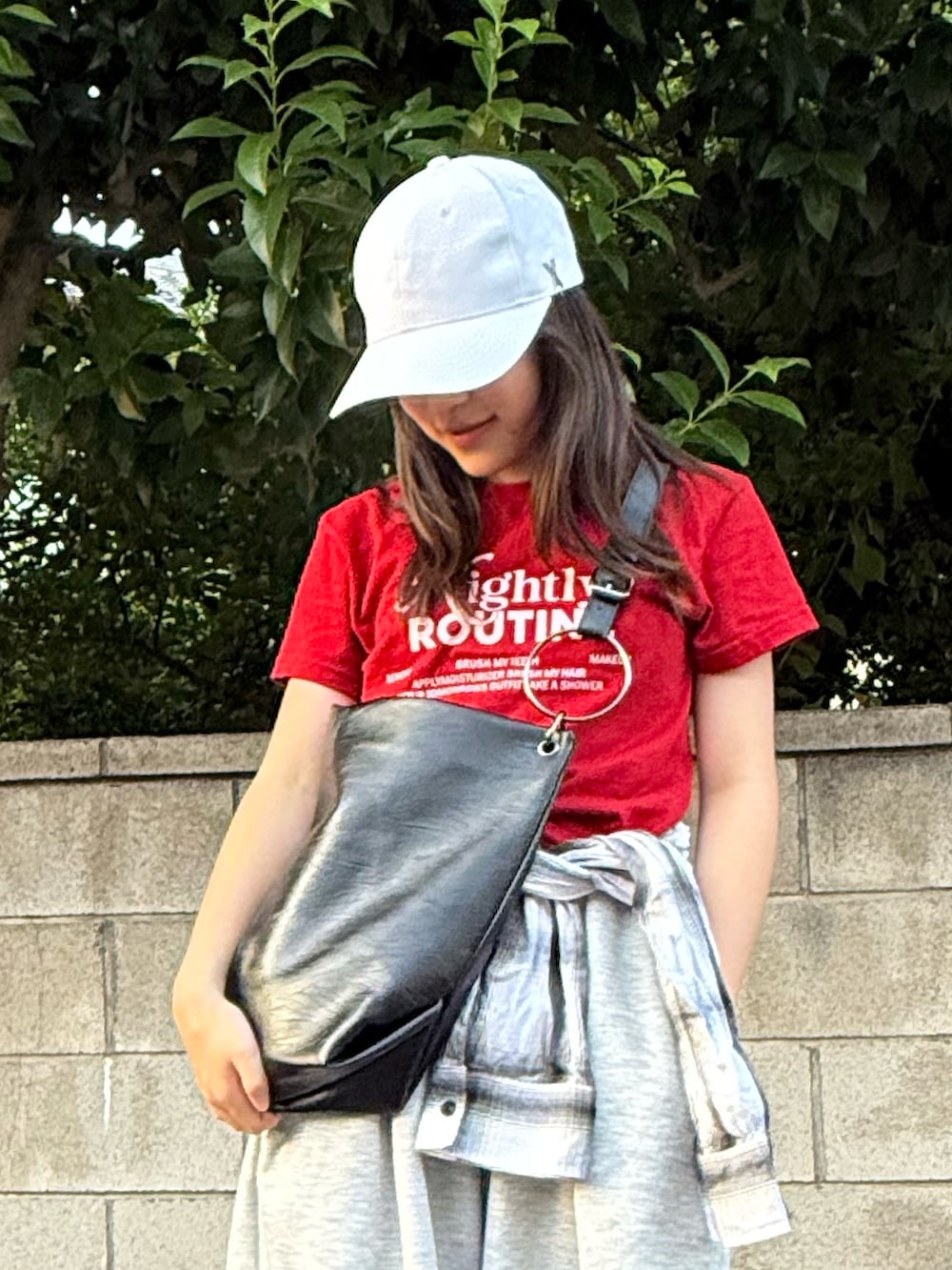 グレー系のスウェットパンツ、レッド系のTシャツ/カットソー、ブラック系のトートバッグを着用したレディースの秋コーディネートの5枚目の写真