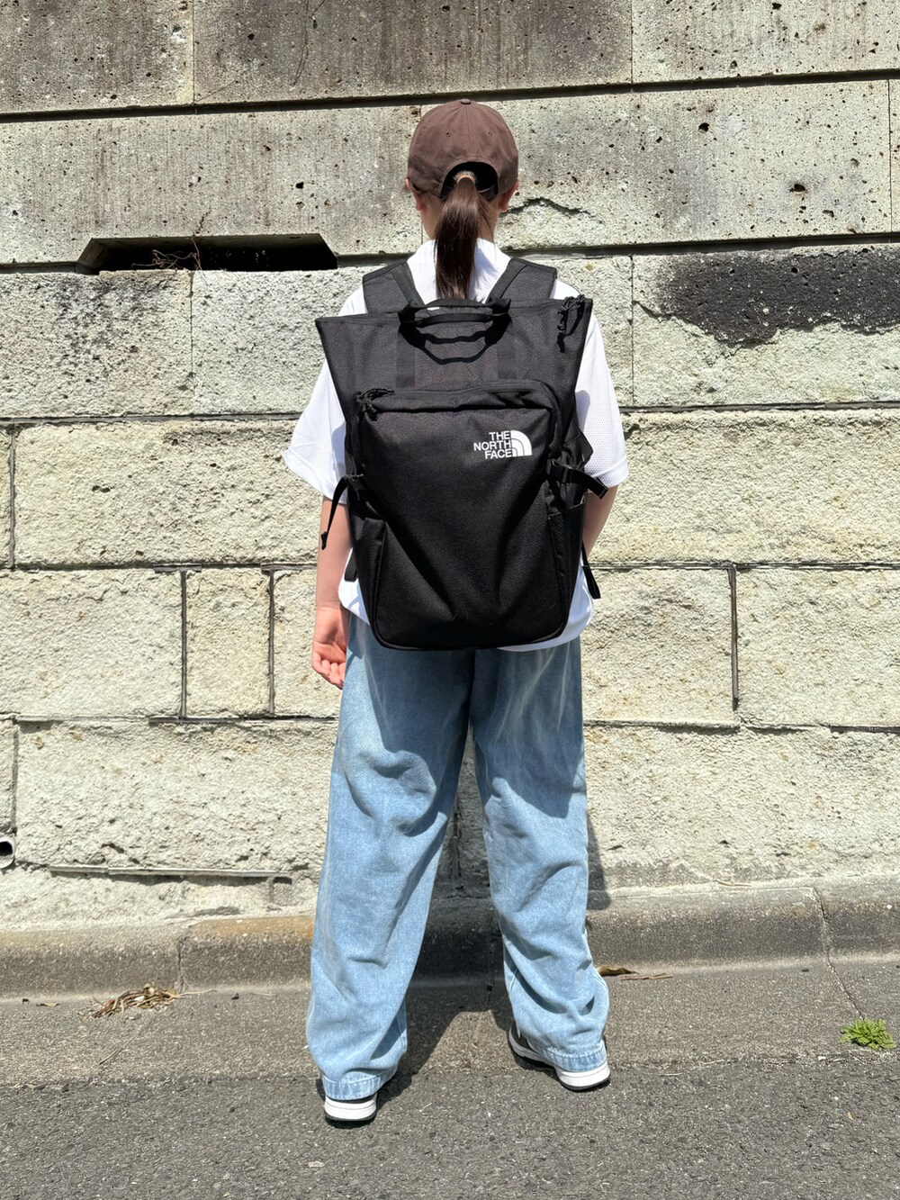 ホワイト系のTシャツ/カットソー、ブルー系のデニムパンツ、ブラック系のバックパック/リュックを着用したキッズの春コーディネートの4枚目の写真