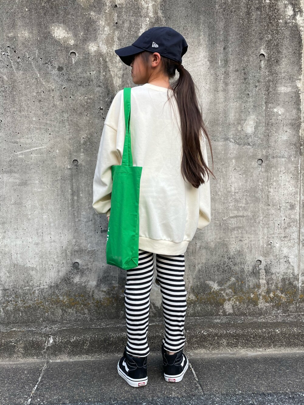 ホワイト系のスウェット、グリーン系のトートバッグ、ブラック系のスニーカーを着用したキッズの春コーディネートの2枚目の写真