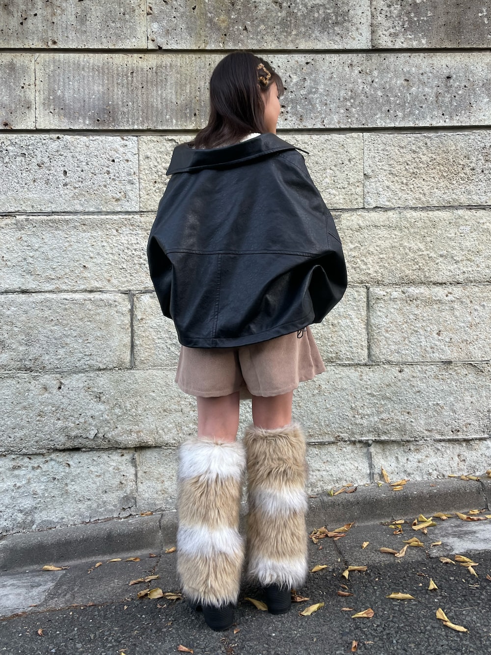 ブラック系のブルゾン、ホワイト系のニット/セーター、ベージュ系のスカートを着用したキッズの冬コーディネートの3枚目の写真