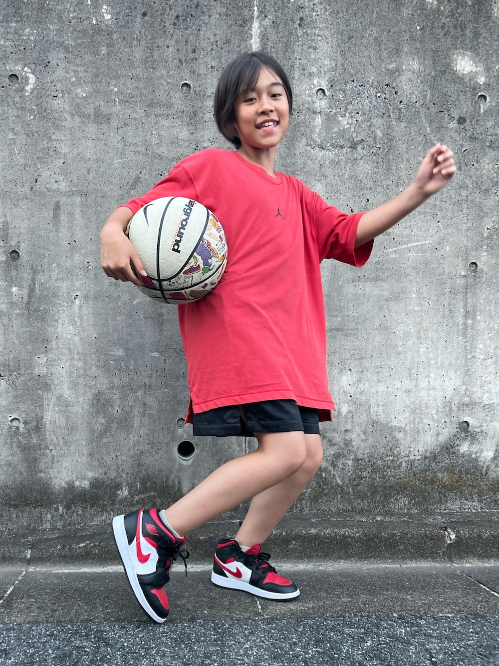 レッド系のTシャツ/カットソー、ブラック系のその他パンツ、ブラック系のスニーカーを着用したキッズの秋コーディネートの3枚目の写真