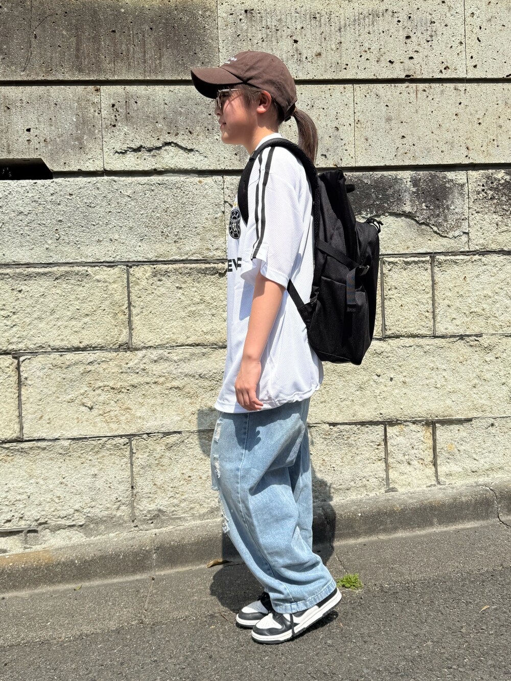ホワイト系のTシャツ/カットソー、ブルー系のデニムパンツ、ブラック系のバックパック/リュックを着用したキッズの春コーディネートの3枚目の写真