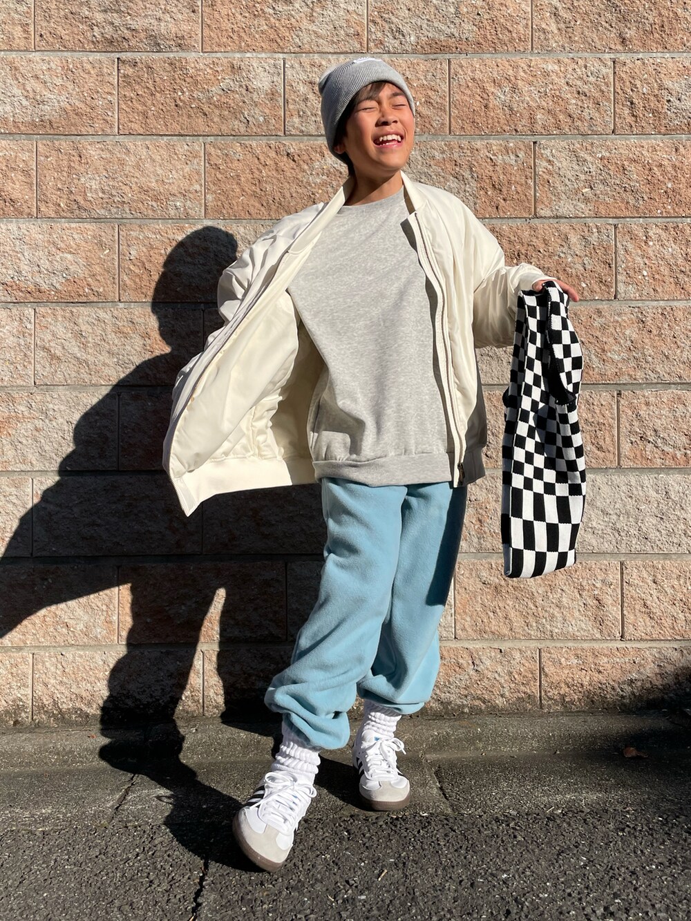 ホワイト系のミリタリージャケット、グレー系のスウェット、ブルー系のその他パンツを着用したキッズの秋コーディネートの5枚目の写真
