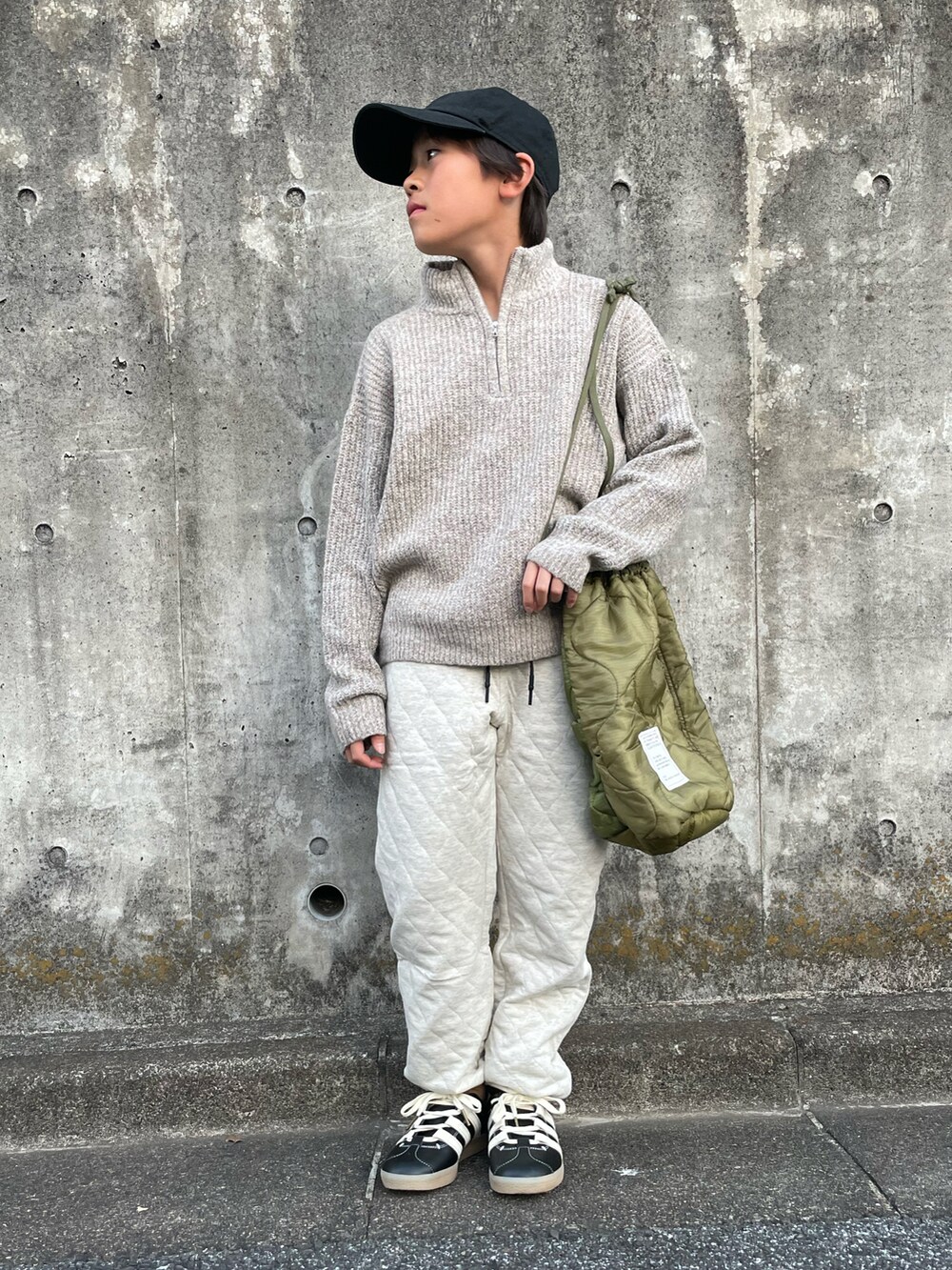 ベージュ系のニット/セーター、ベージュ系のスウェットパンツ、グリーン系のショルダーバッグを着用したキッズの冬コーディネートの2枚目の写真