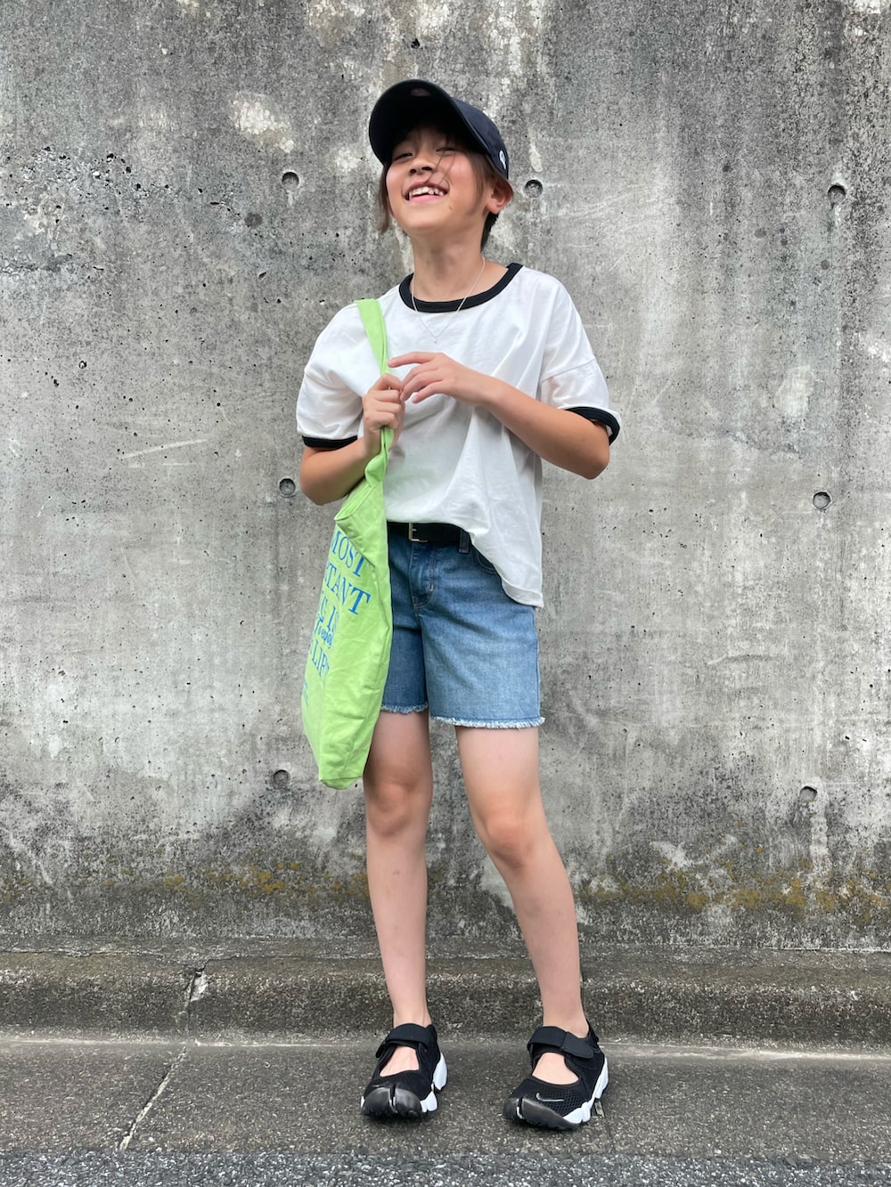 ホワイト系のTシャツ/カットソー、ブルー系のデニムパンツ、グリーン系のトートバッグを着用したキッズの夏コーディネートの5枚目の写真