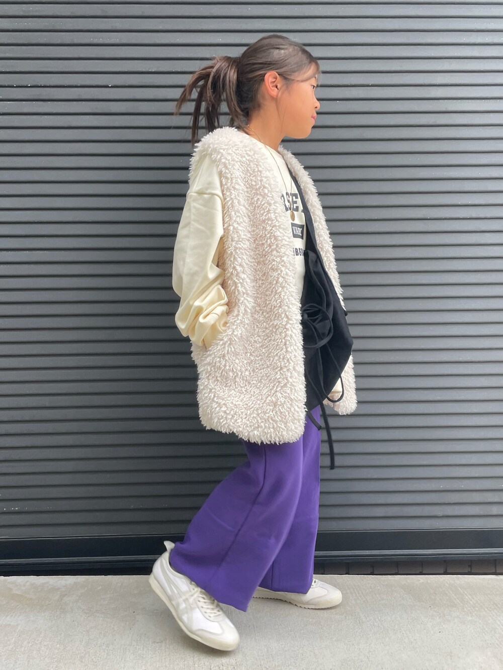ホワイト系のベスト、ホワイト系のスウェット、パープル系のその他パンツを着用したキッズの秋コーディネートの2枚目の写真