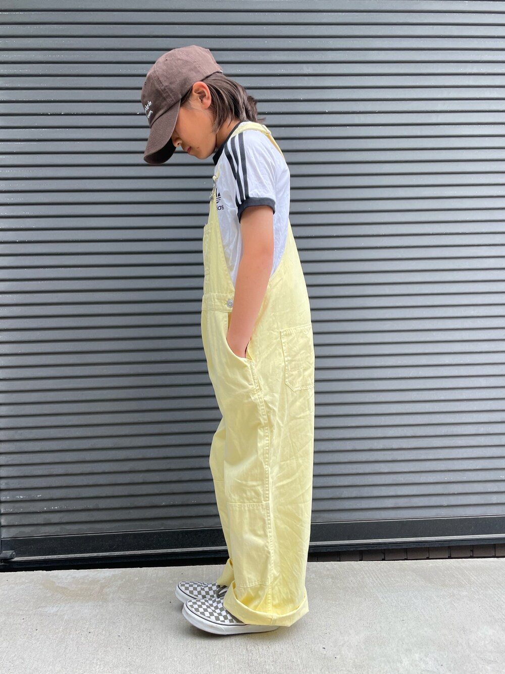 イエロー系のサロペット/オーバーオール、ホワイト系のTシャツ/カットソー、グリーン系のスニーカーを着用したキッズの春コーディネートの4枚目の写真