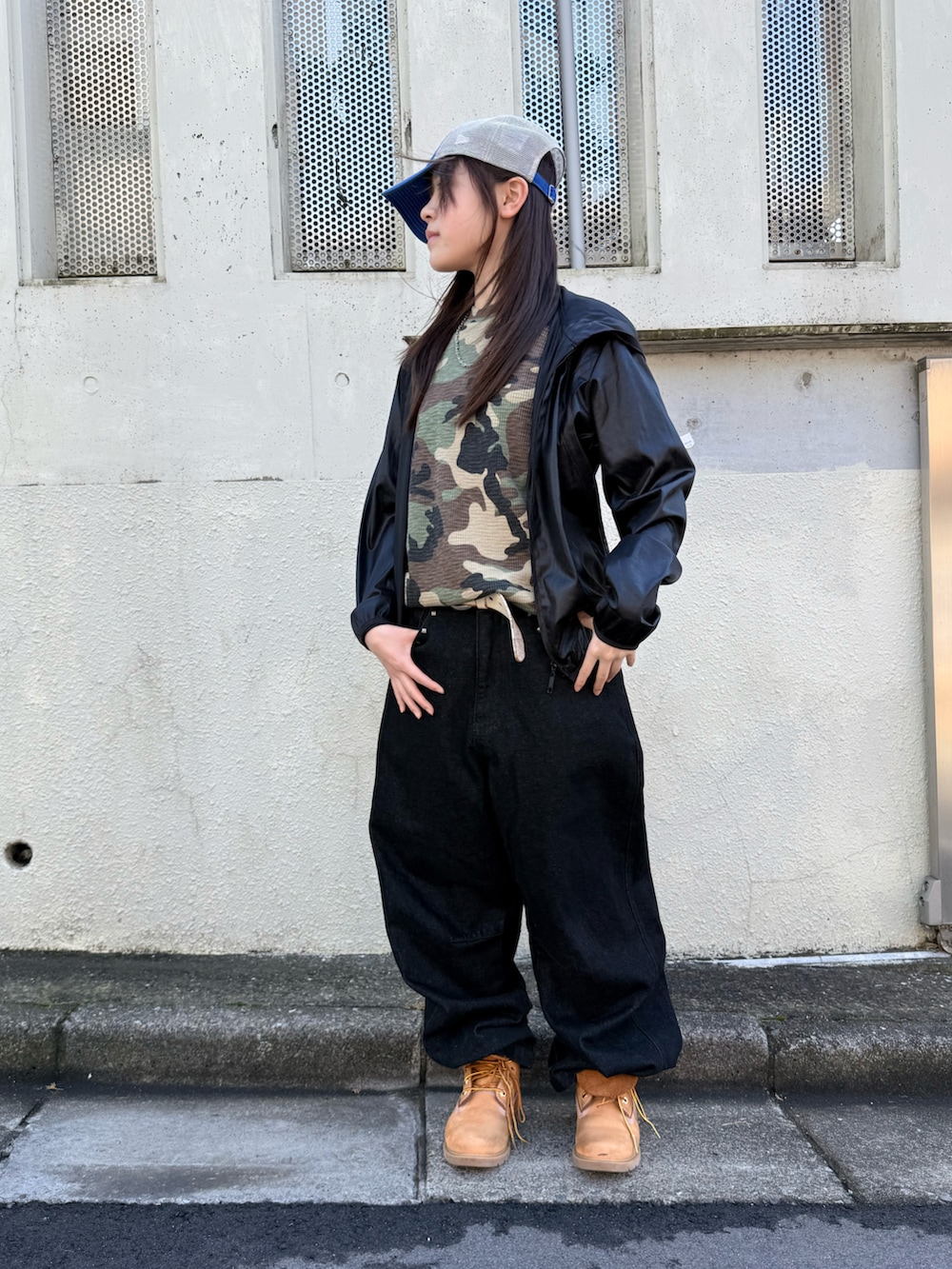 ブラック系のブルゾン、ベージュ系のブーツ、グリーン系のTシャツ/カットソーを着用したレディースの冬コーディネートの3枚目の写真