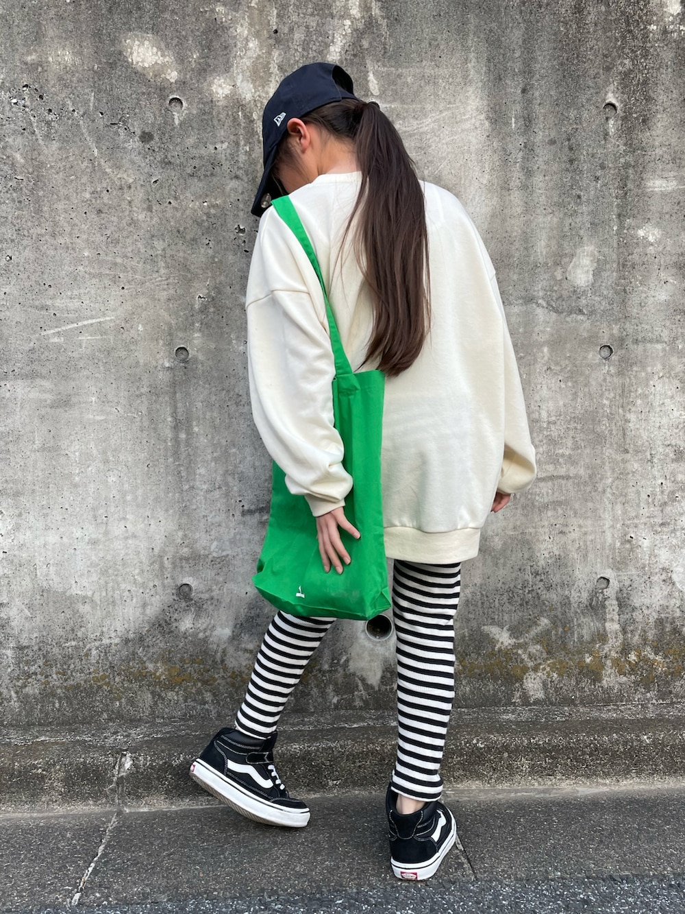 ホワイト系のスウェット、グリーン系のトートバッグ、ブラック系のスニーカーを着用したキッズの春コーディネートの3枚目の写真