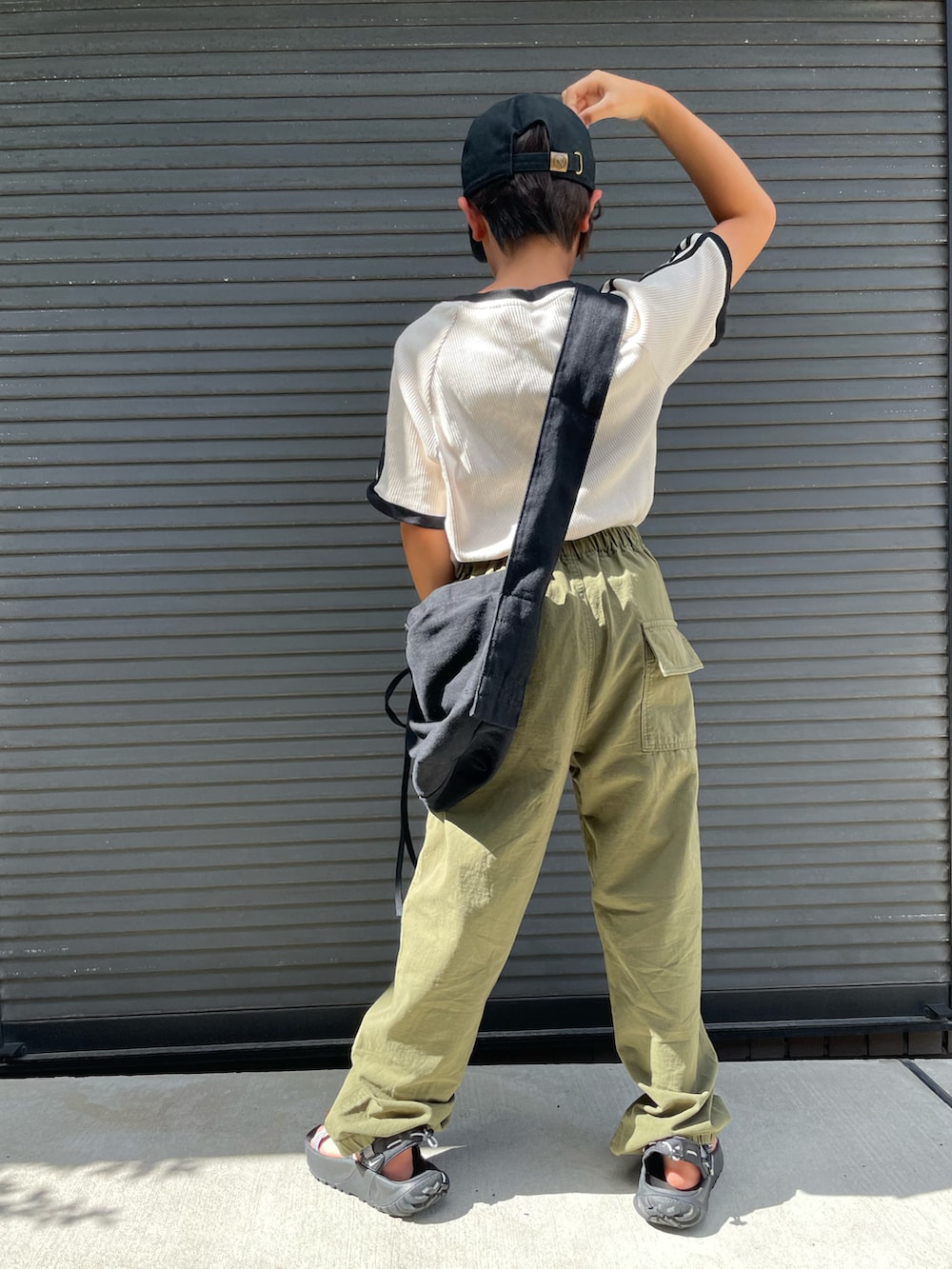 ホワイト系のTシャツ/カットソー、グリーン系のカーゴパンツ、ブラック系のショルダーバッグを着用したキッズの夏コーディネートの3枚目の写真