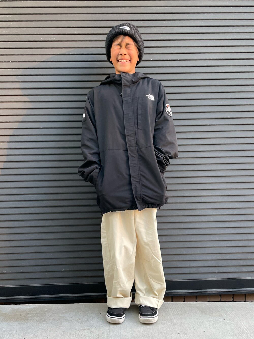 ブラック系のマウンテンパーカー、ホワイト系のカーゴパンツ、ブラック系のスニーカーを着用したキッズの秋コーディネートの4枚目の写真