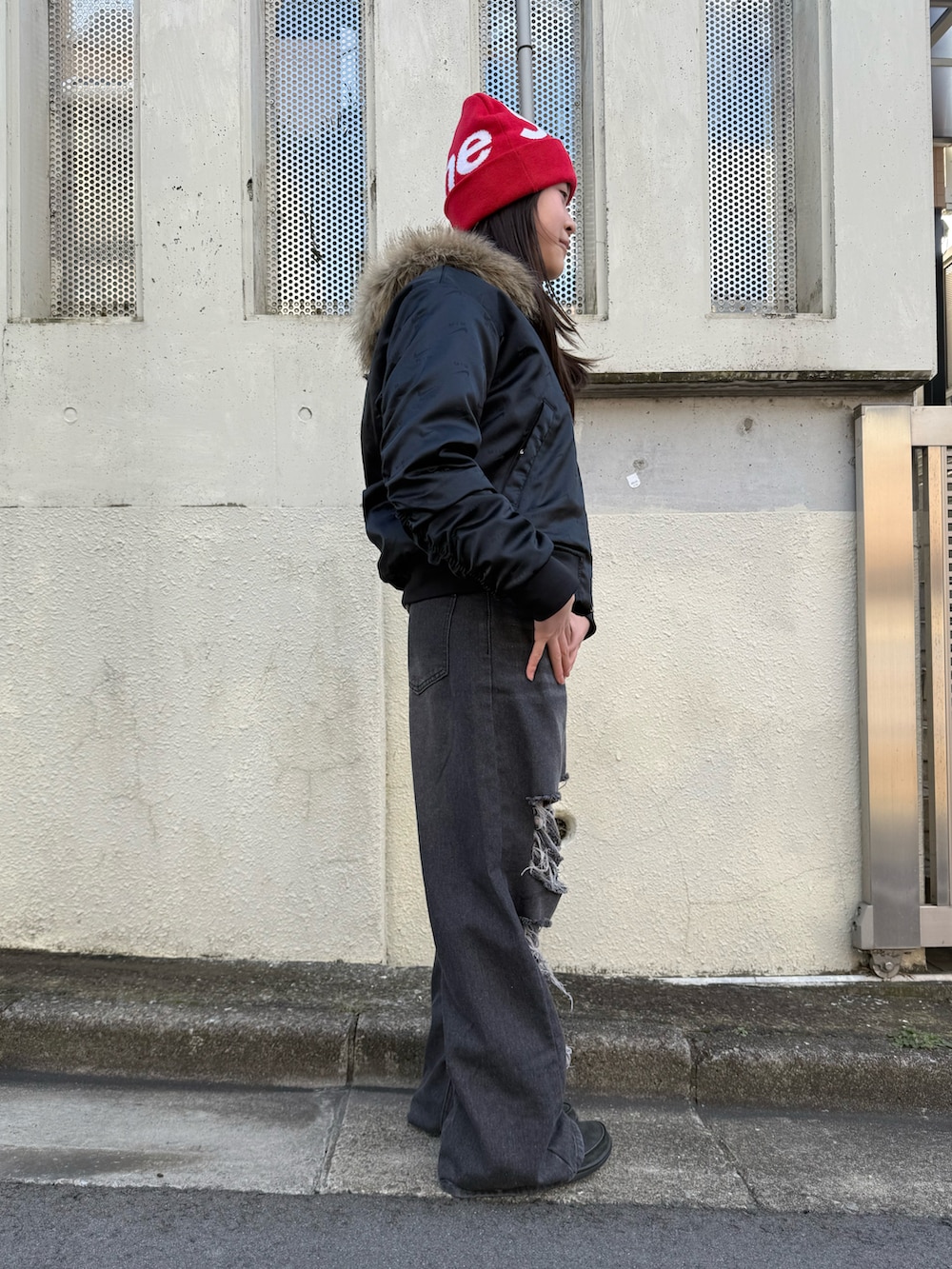 ブラック系のデニムパンツ、グリーン系のパーカー、ブラック系のブルゾンを着用したレディースの冬コーディネートの3枚目の写真